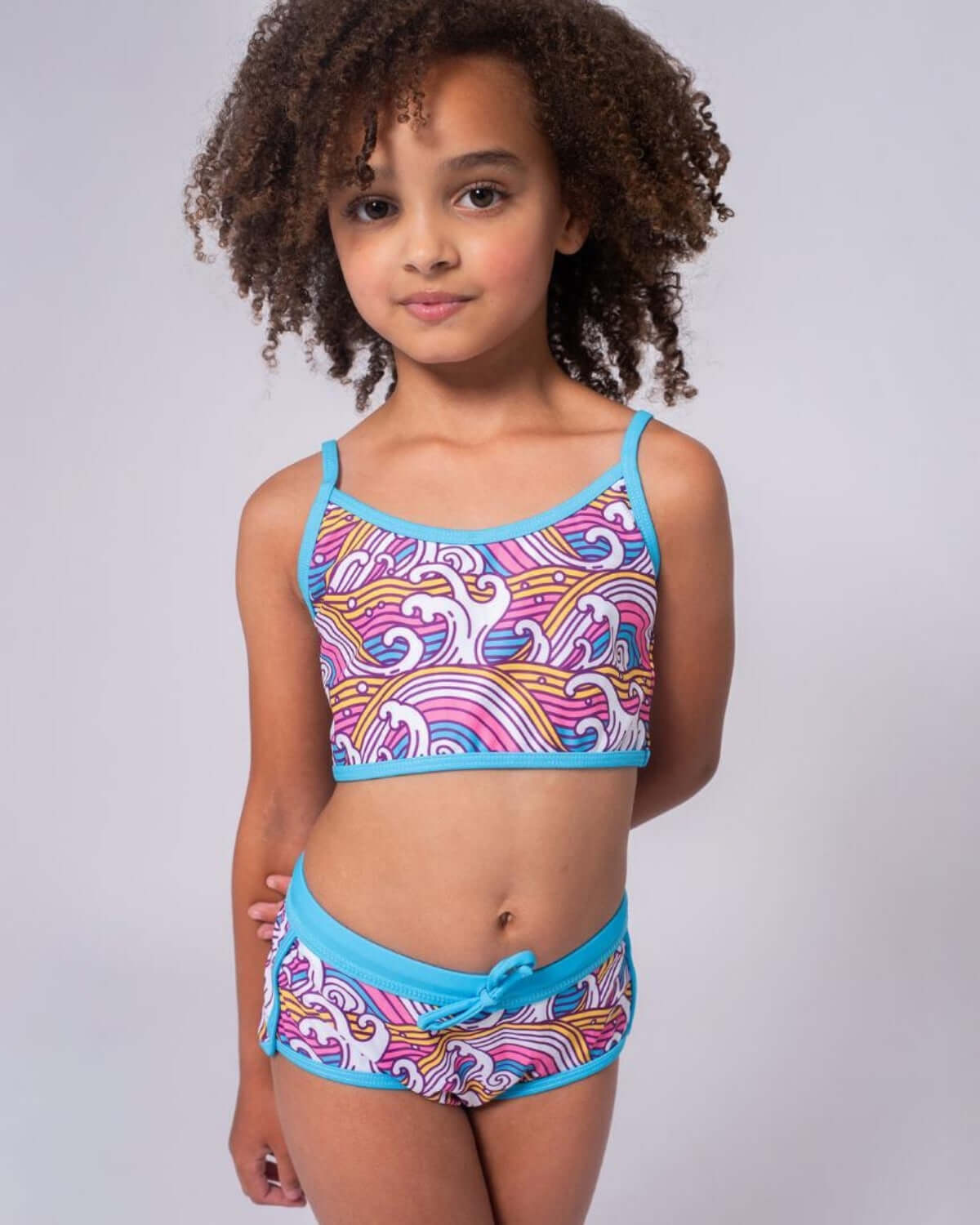 Waves Stella Bikini featuring a girl in a colorful floral and palm design swim set, perfect for summer fun.
