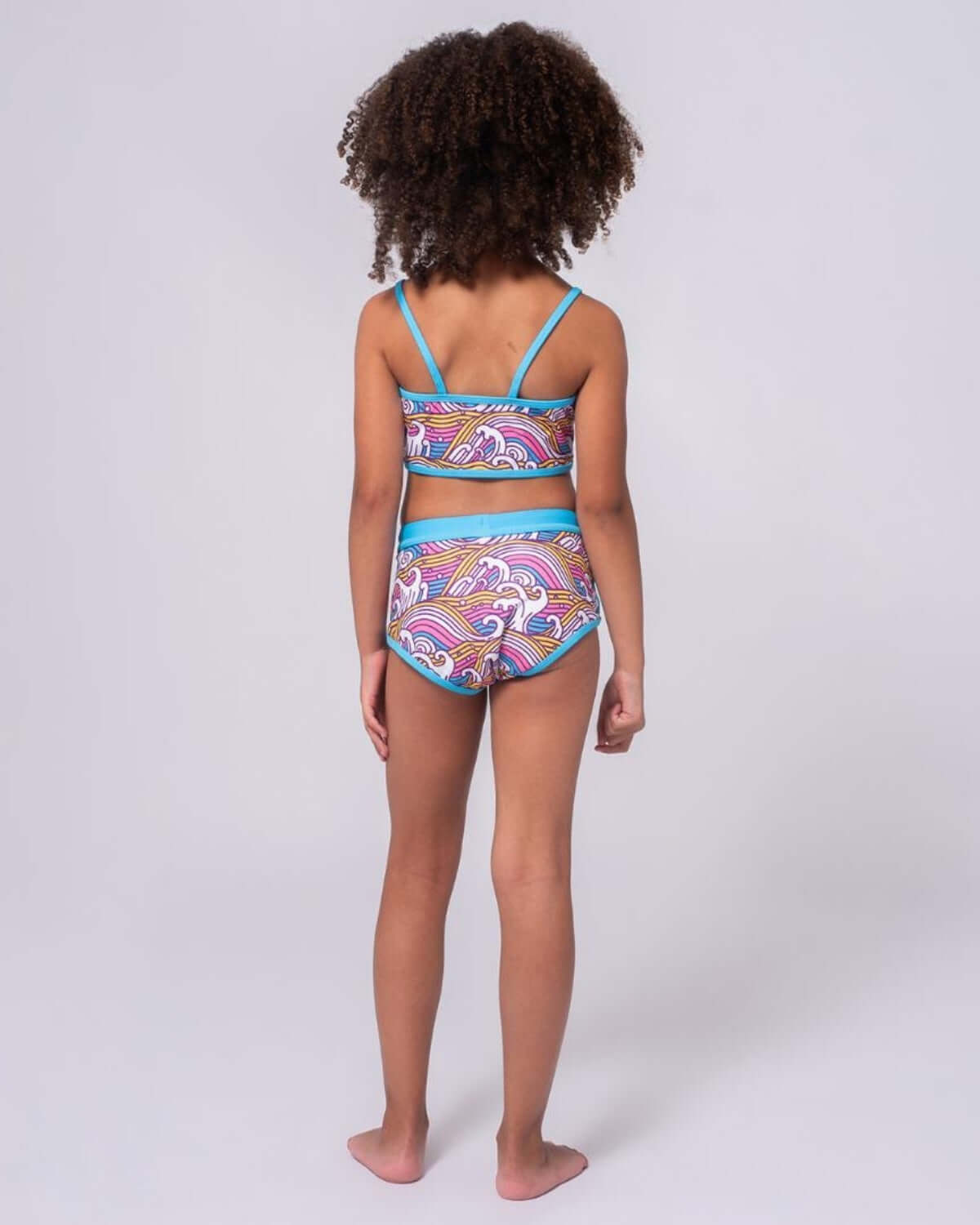 Stylish girl wearing the Waves Stella Bikini, ready for summer fun with vibrant colors and playful patterns.