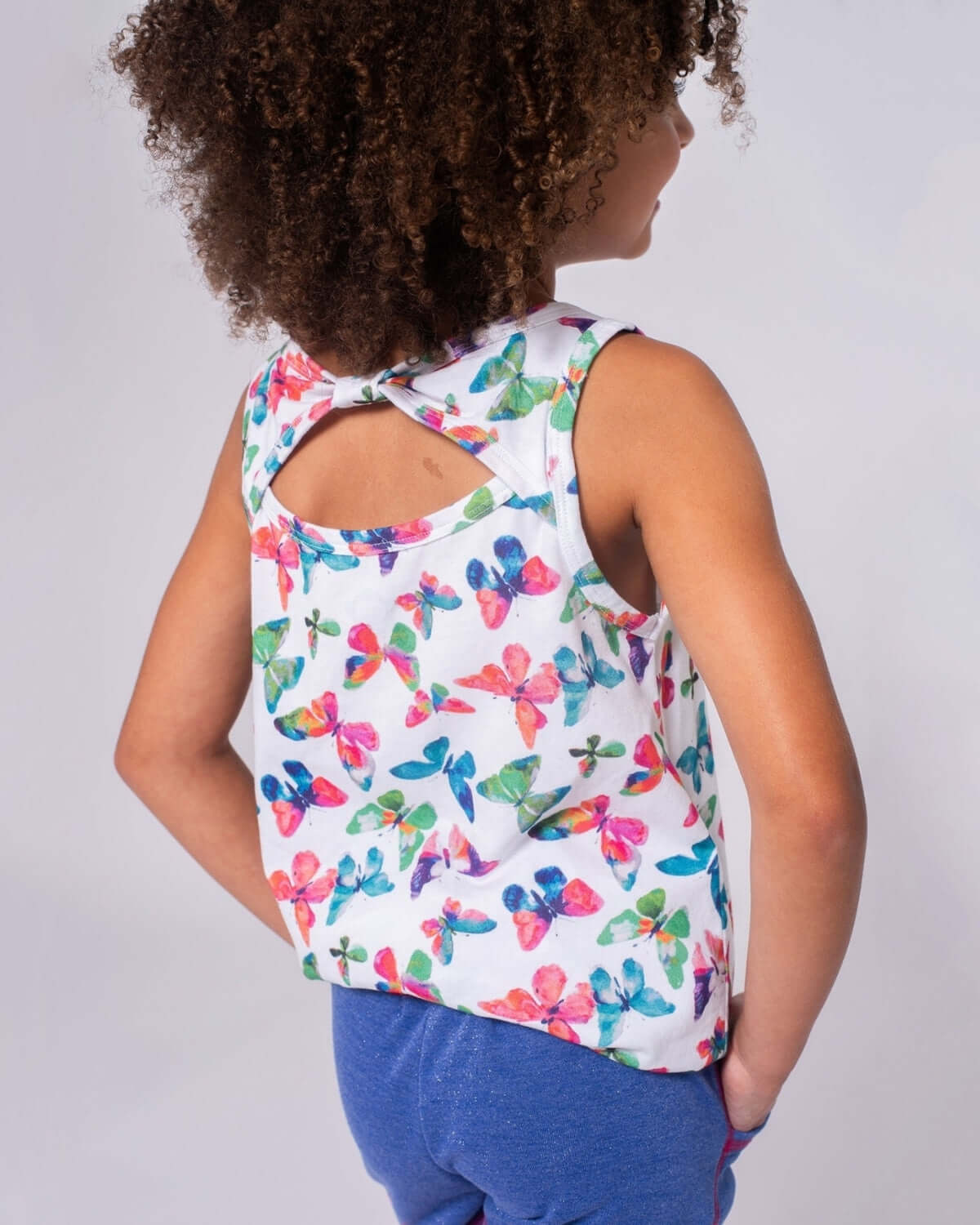 Stylish girl in colorful butterfly print Hazel Top, ready for fun playdates in trendy kids clothes.