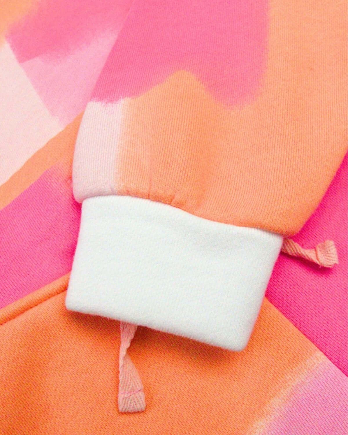 Close-up of the cozy cuff on the vibrant color block Sofia Top, blending orange and pink for a playful fall vibe.