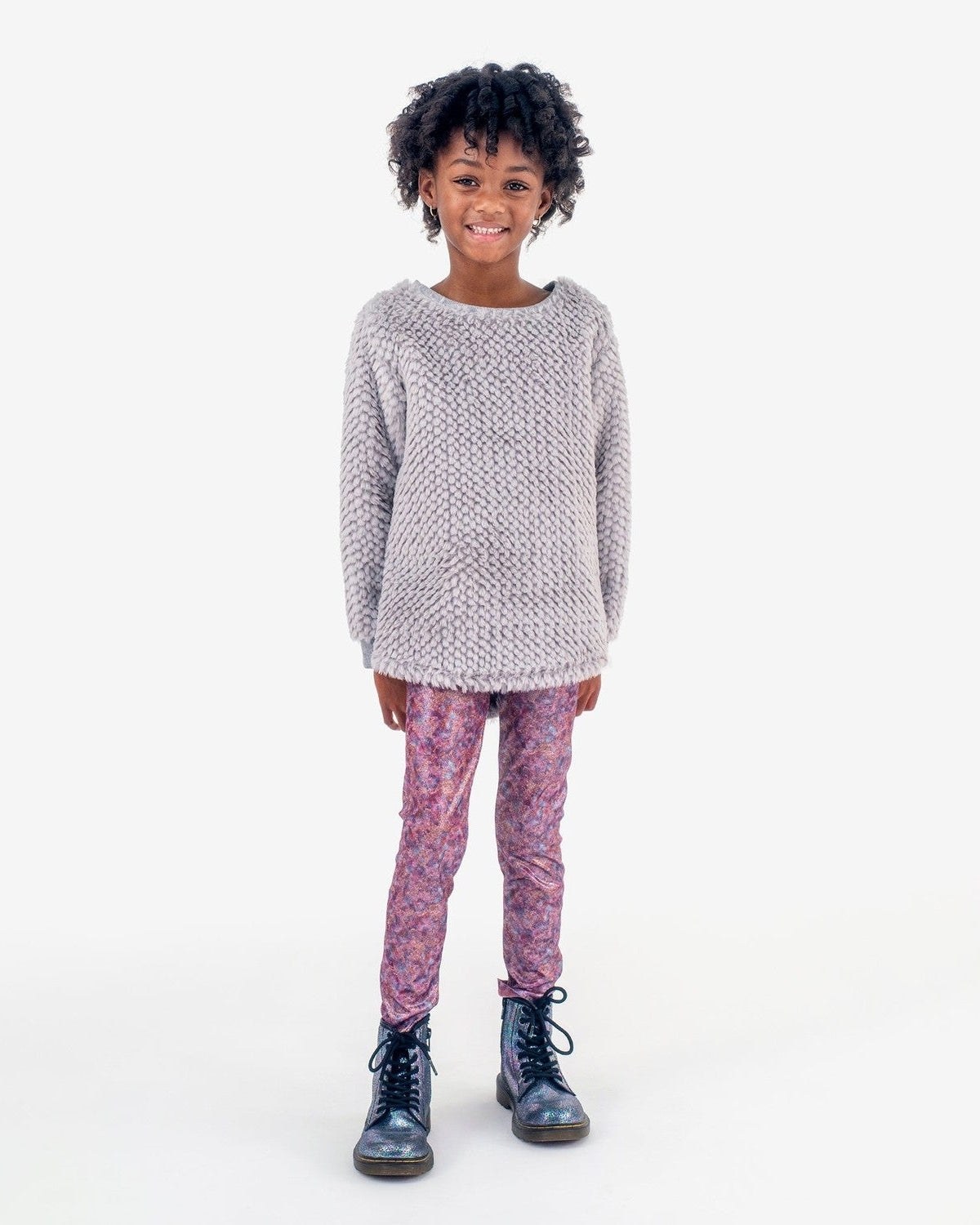 Stylish girl in a cozy grey novelty top and floral leggings, ready for playful fall adventures in high-quality kids clothes.