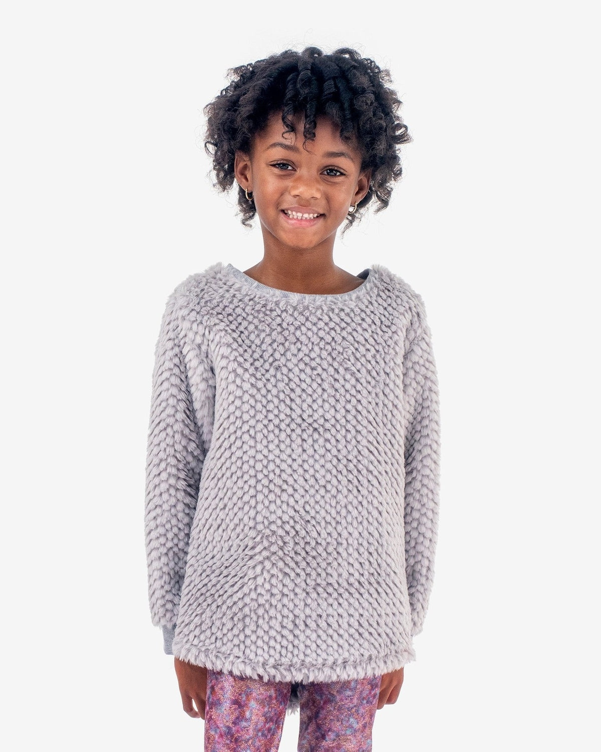 Stylish girl grinning in cozy Grey Novelty Laurel Top, a charming choice for kids' back-to-school outfits.