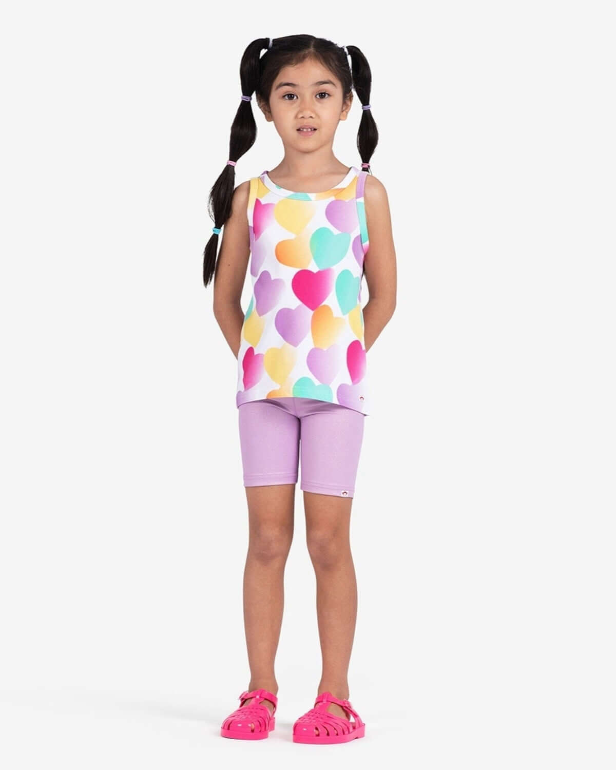 Stylish girl in playful heart tank top and lilac shorts, embodying the fun spirit of kids clothes by Appaman.