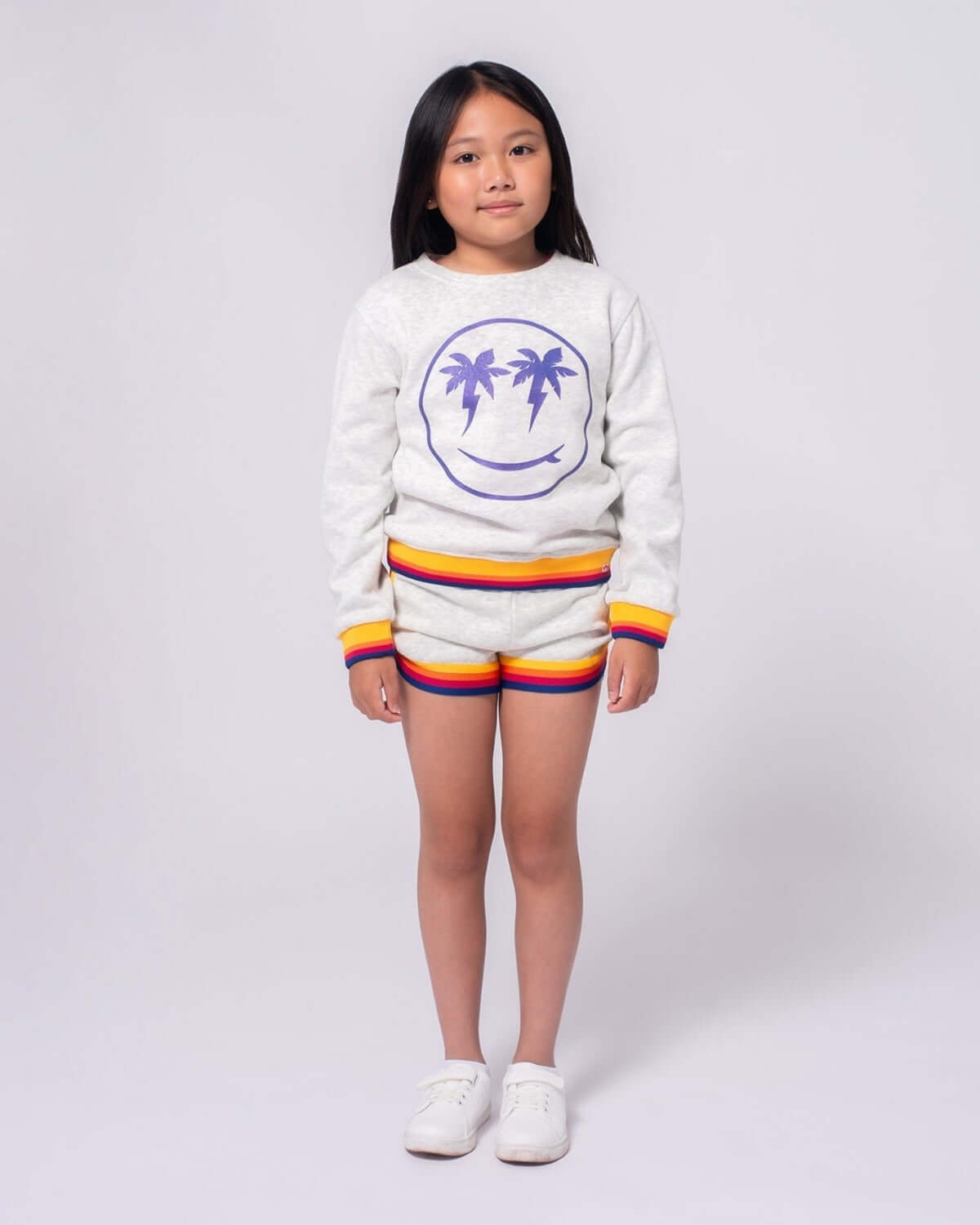Happy Surfing Ruby Sweatshirt on a girl, showcasing vibrant palm trees and smiley face design, perfect kids clothes for fun adventures!