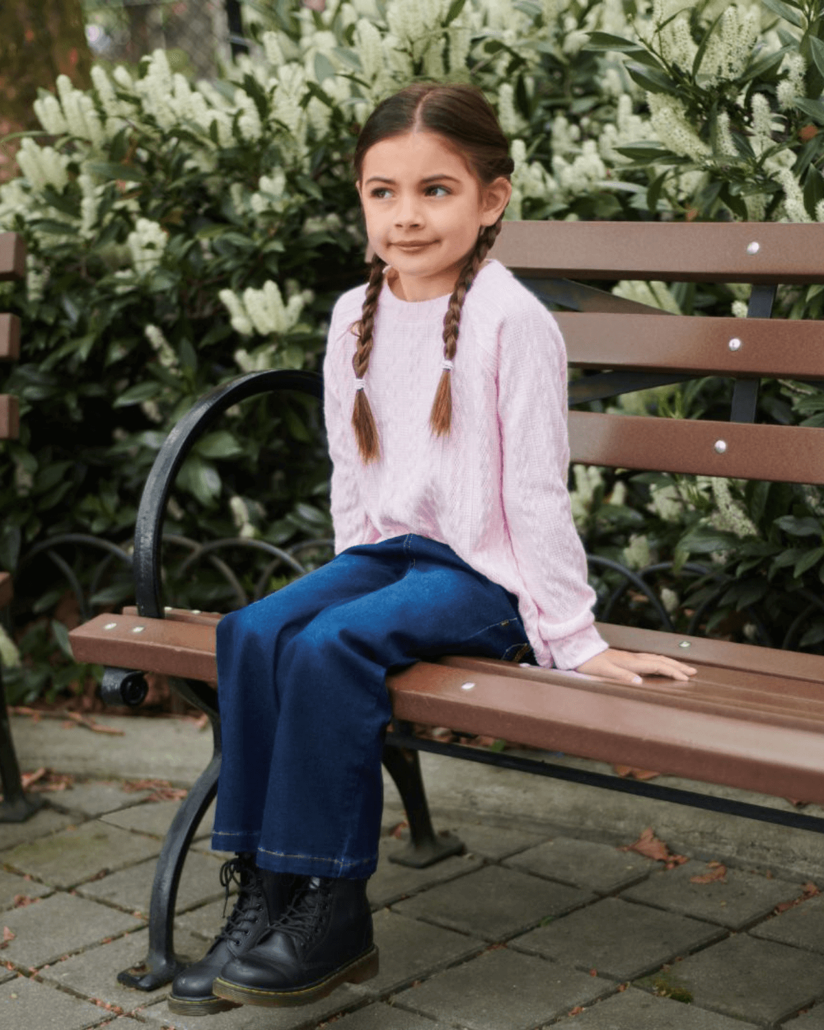 Stylish girl in a pink cable knit sweater, rocking durable denim for school—perfect kids' clothes for confident kiddos!
