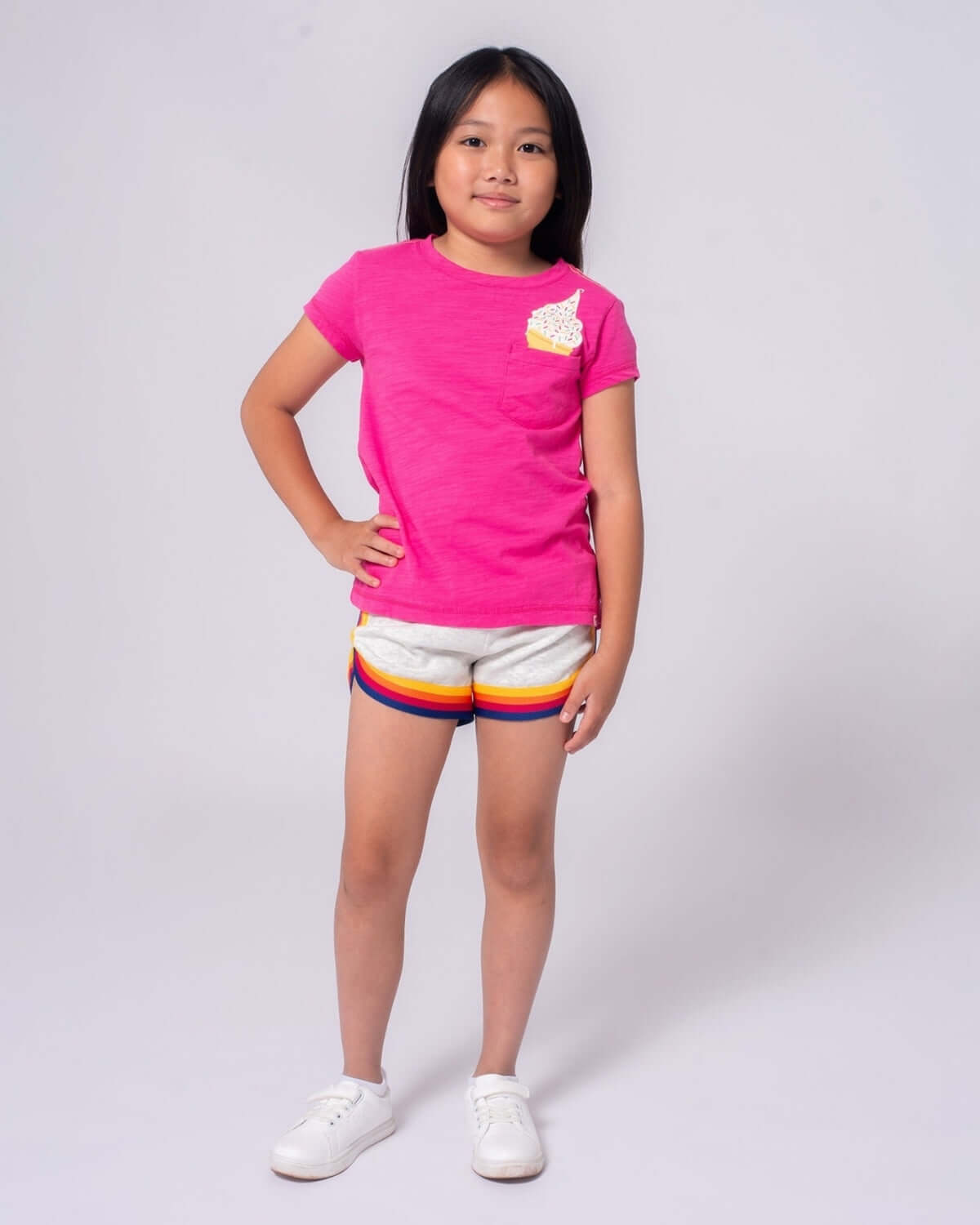 Stylish girl in fuchsia ice cream tee & striped shorts, ready for fun adventures in high-quality kids clothes!