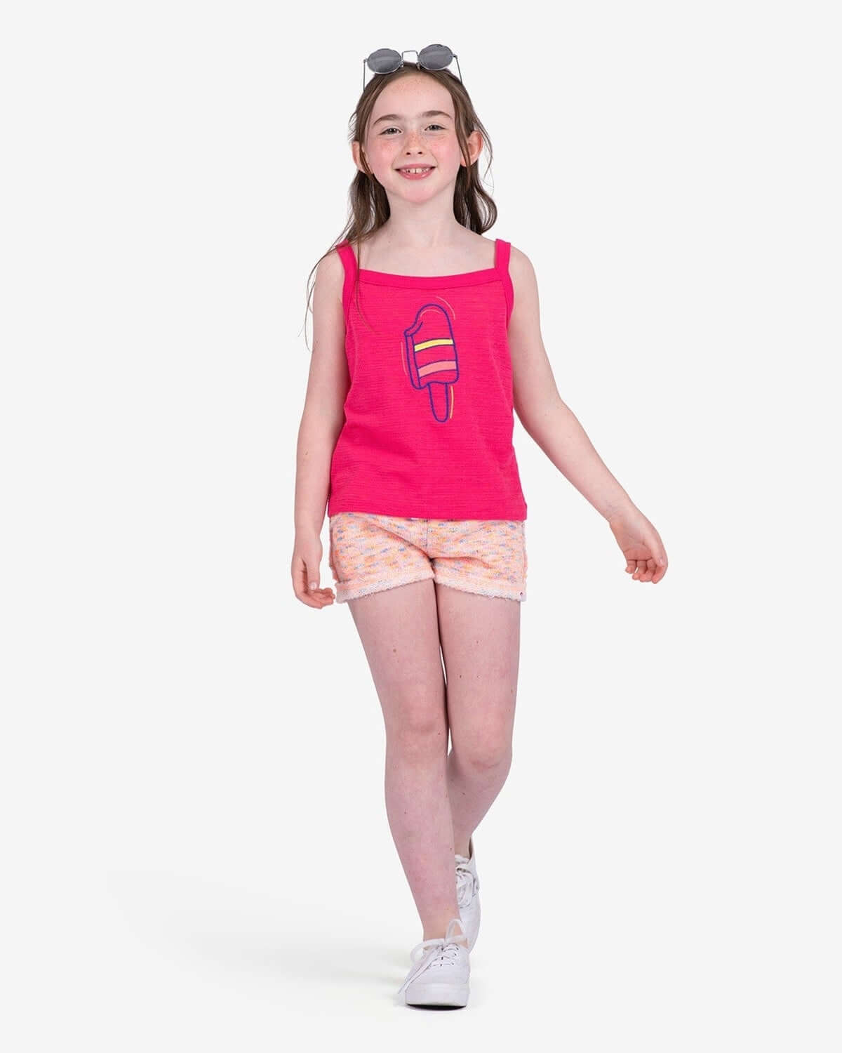 Stylish girl in a vibrant pink Popsicle Hannah Tank and colorful shorts, ready for summer fun and adventure!