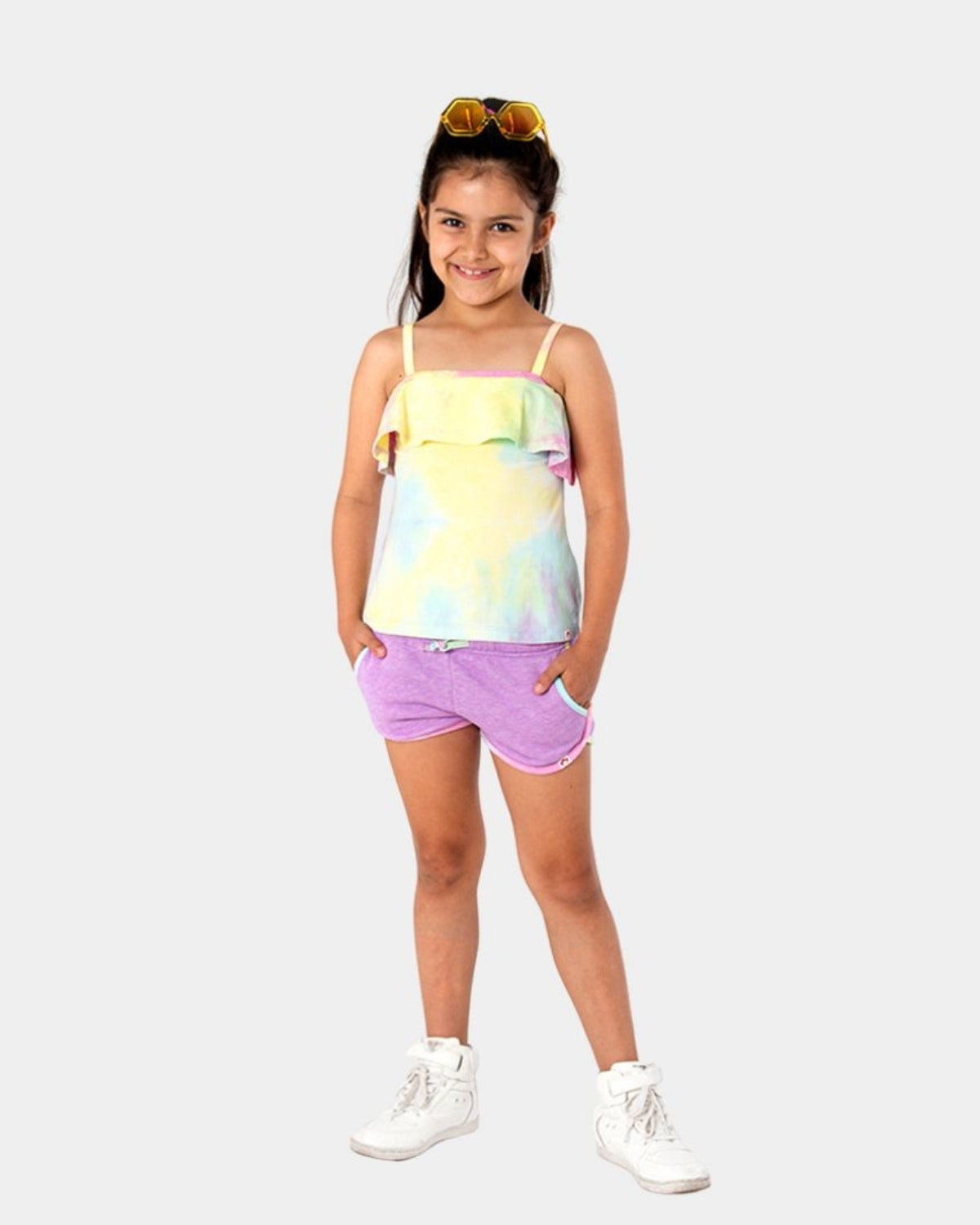 Playful girl in Rainbow Sherbet Avila Tank with fluttery cap sleeves, styled with Sierra Shorts in Periwinkle and cool kicks.