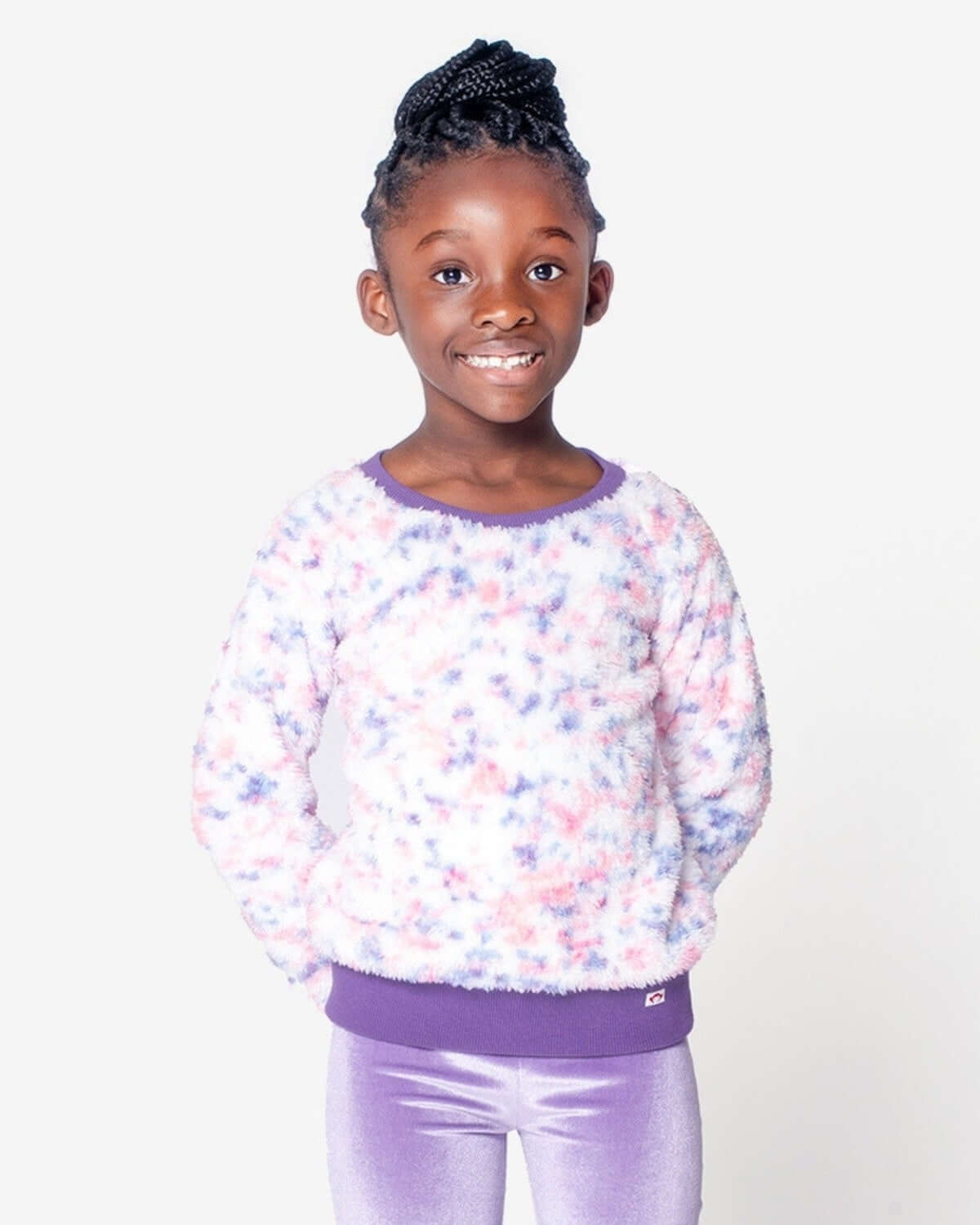A joyful girl in a cozy Speckled Cloud Willow Top, radiating playful style with fluffy texture and vibrant colors.