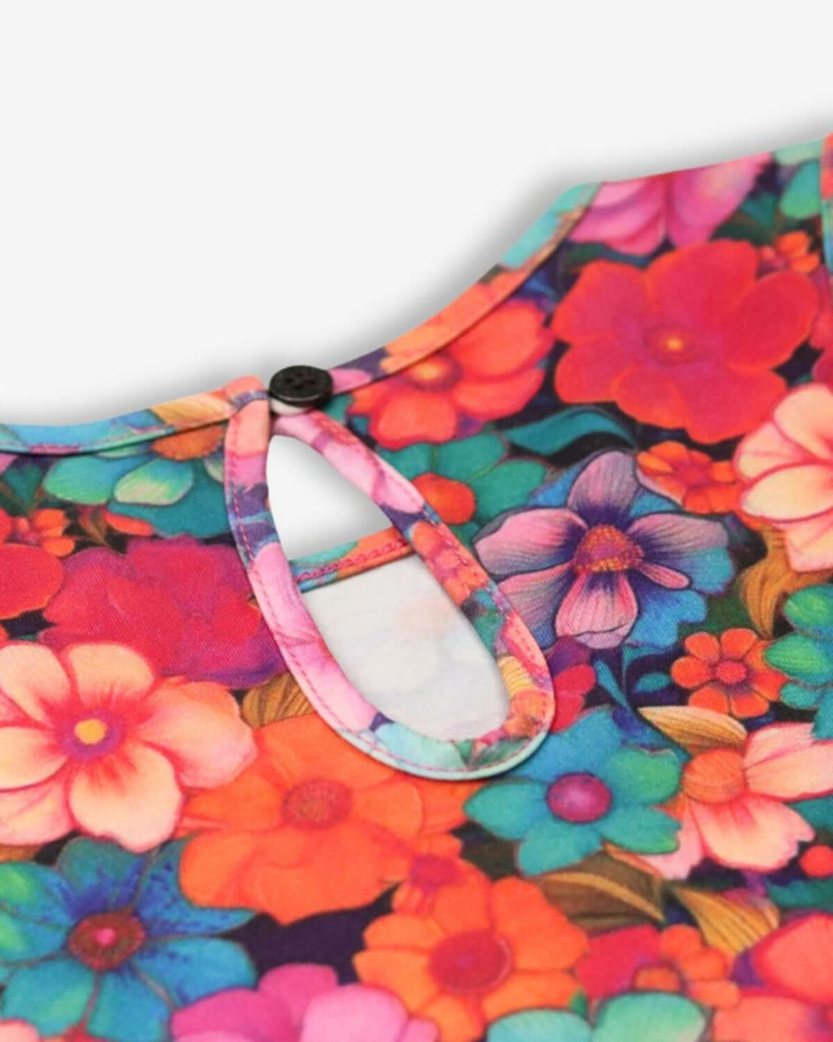 Vibrant floral close-up of the Summer Bloom Hazel Top, showcasing playful colors and stylish button detail.