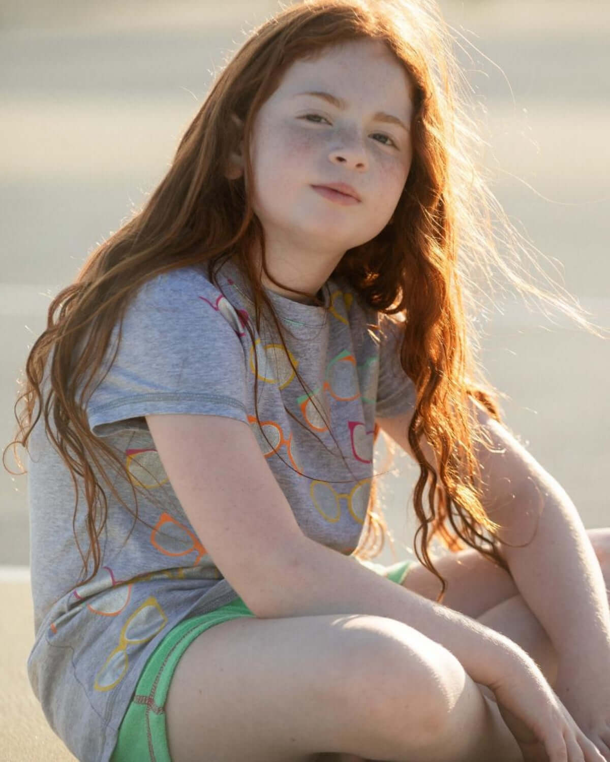 Cool kid rocking a light grey sunglasses circle tee, enjoying sunny vibes on a playful day—perfect for back to school fun!