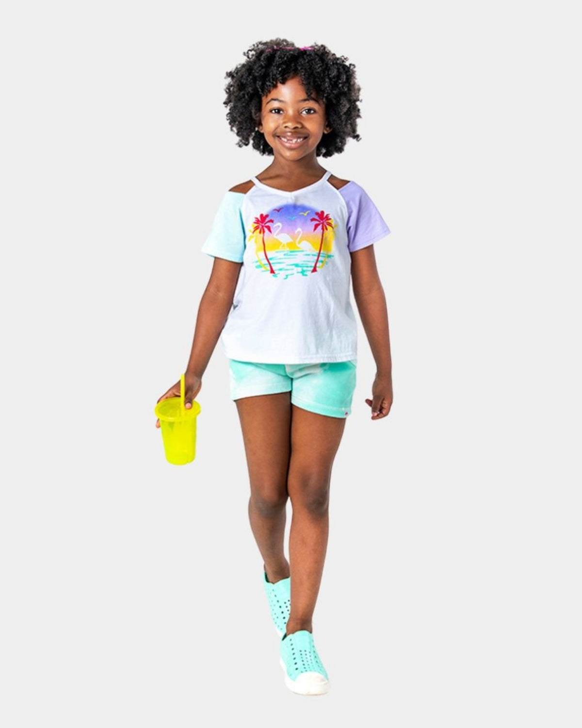 Stylish girl in Sunset Kari Tee, strutting with confidence, showcasing vibrant sunset graphic—perfect summer fun in kids clothes.