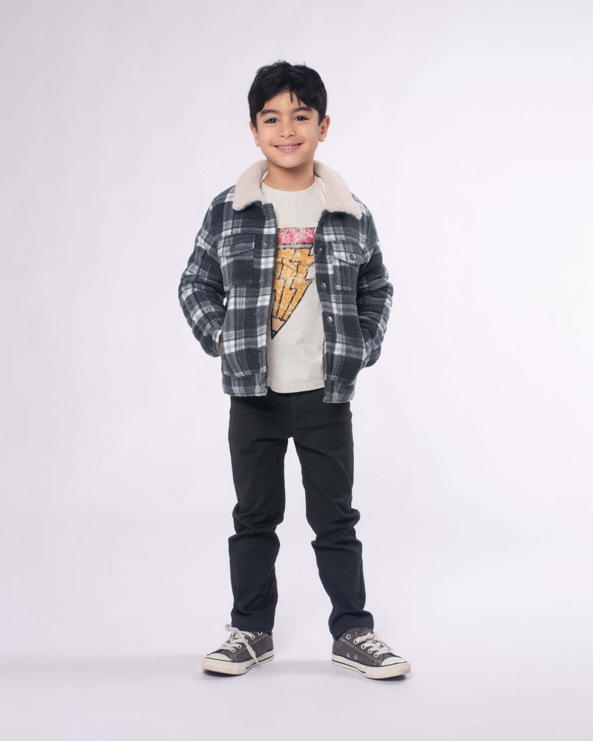 Stylish young boy in flannel jacket and graphic tee, showcasing trendy kids clothes for boys—perfect back to school look!
