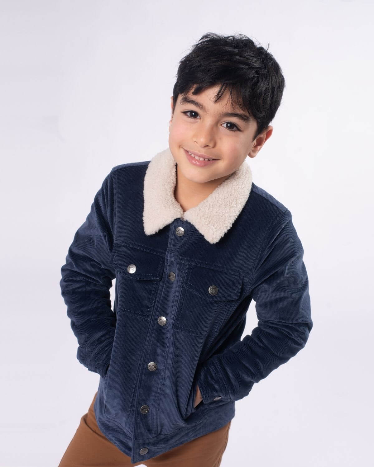 Stylish boy in a cozy navy blue Heritage Jacket with soft Sherpa collar—perfect for kids' stylish adventures!
