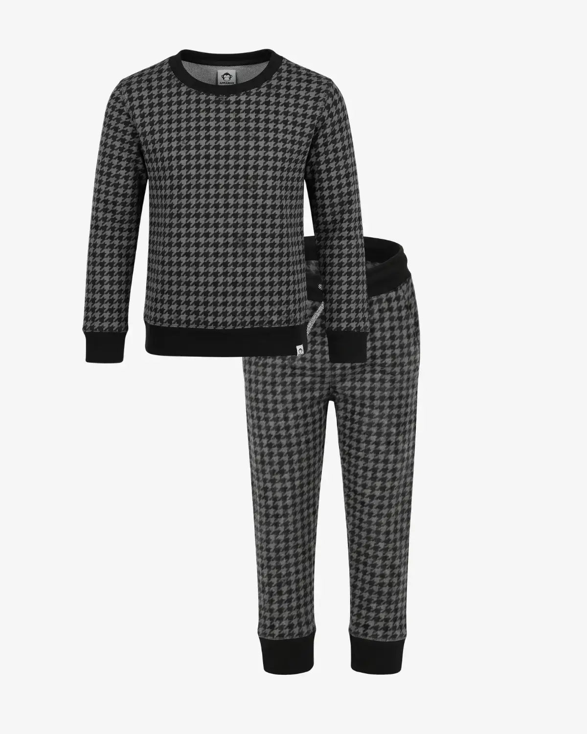 A two-piece children's pajama set featuring a long-sleeve top and matching pants in a black and gray houndstooth pattern, with solid black ribbed cuffs, collar, and hem on the top, and solid black waistband and cuffs on the pants.