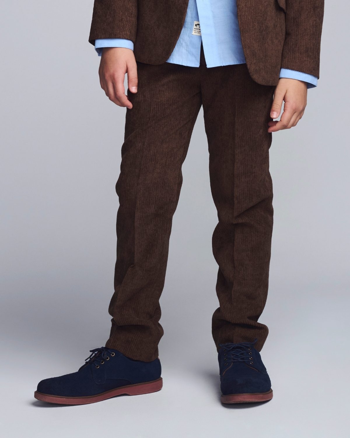 Person wearing brown corduroy pants with a plain background