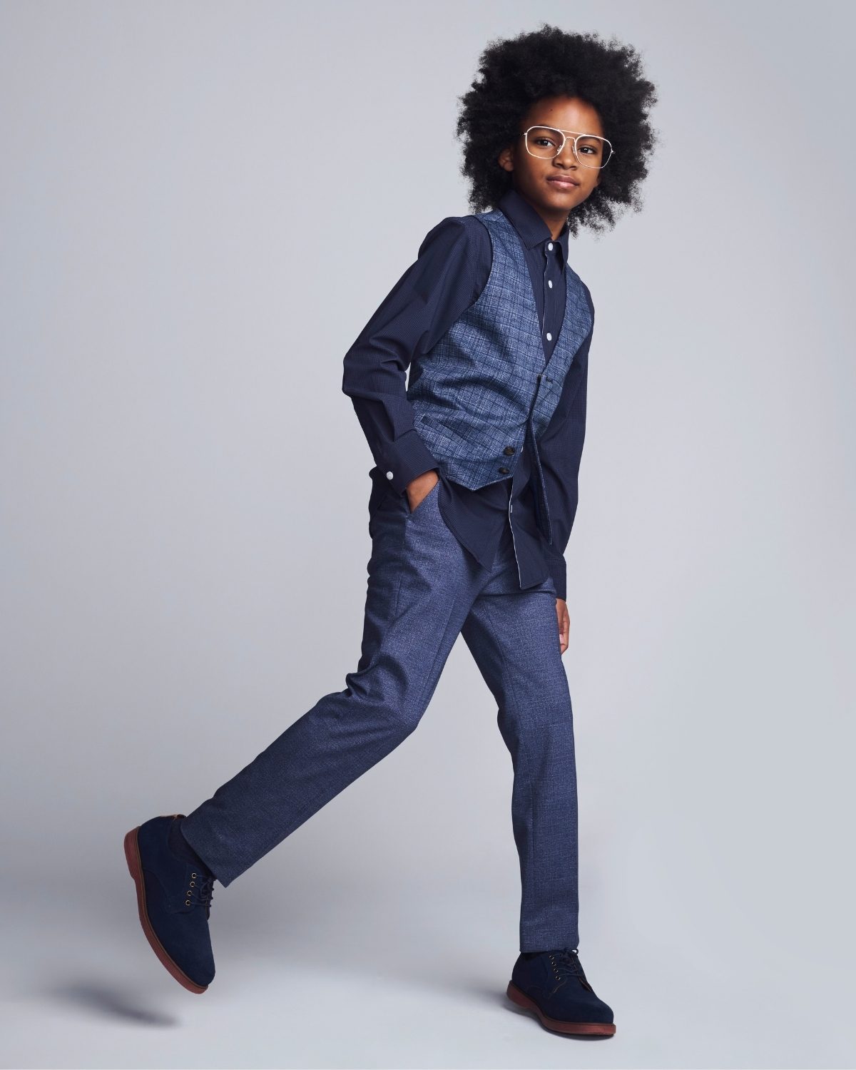 Person wearing a blue outfit with a jacket and pants on a plain background