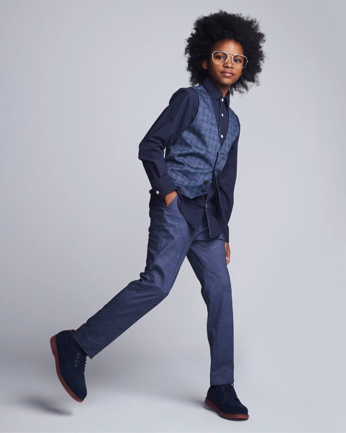 Person wearing a blue outfit with a jacket and pants on a plain background