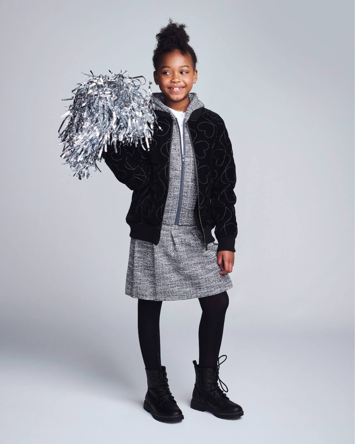 Child holding tinsel against a plain background