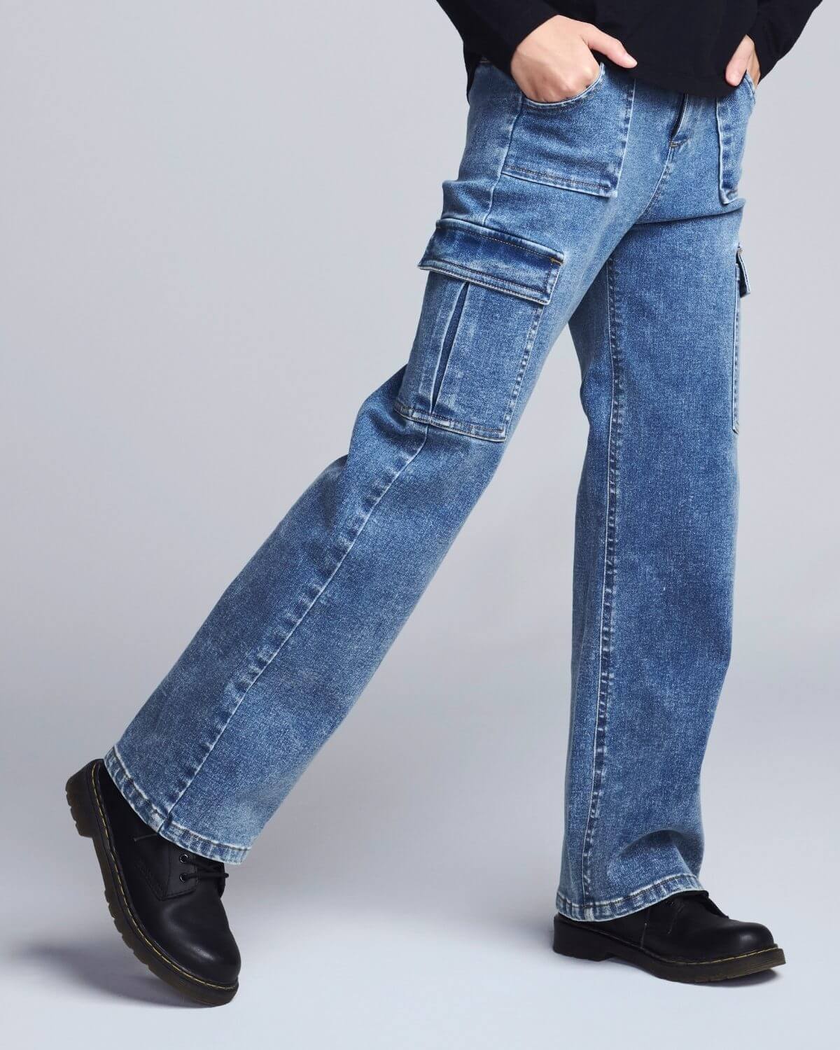 Blue jeans worn by a person on a light gray background