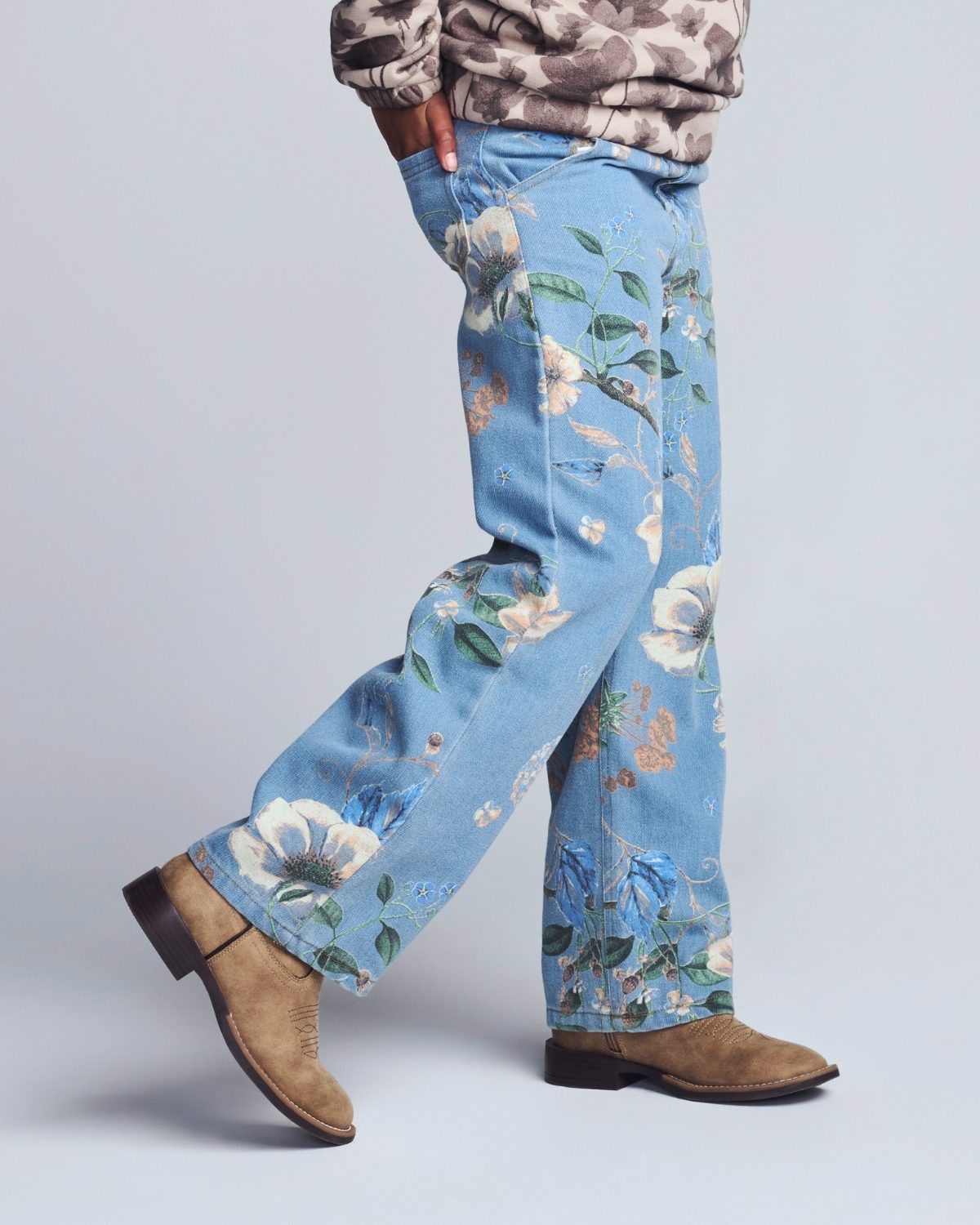 Person wearing blue floral pants with a plain background