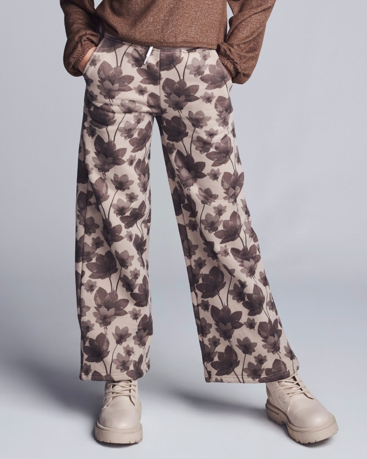 Floral patterned pants worn by a person on a plain background