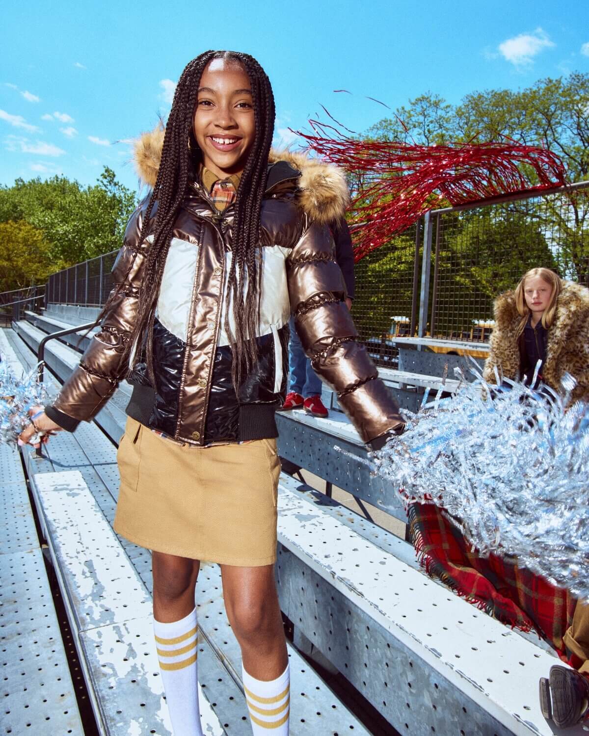 Person wearing a metallic jacket with fur hood in an outdoor setting