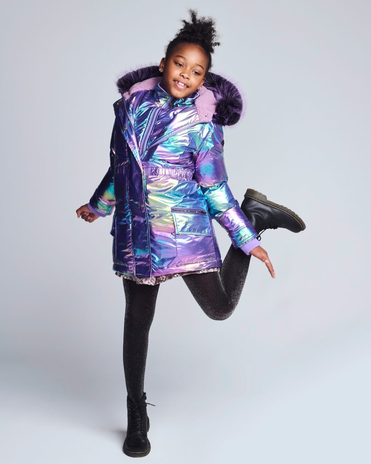 Child wearing a colorful, iridescent jacket on a white background