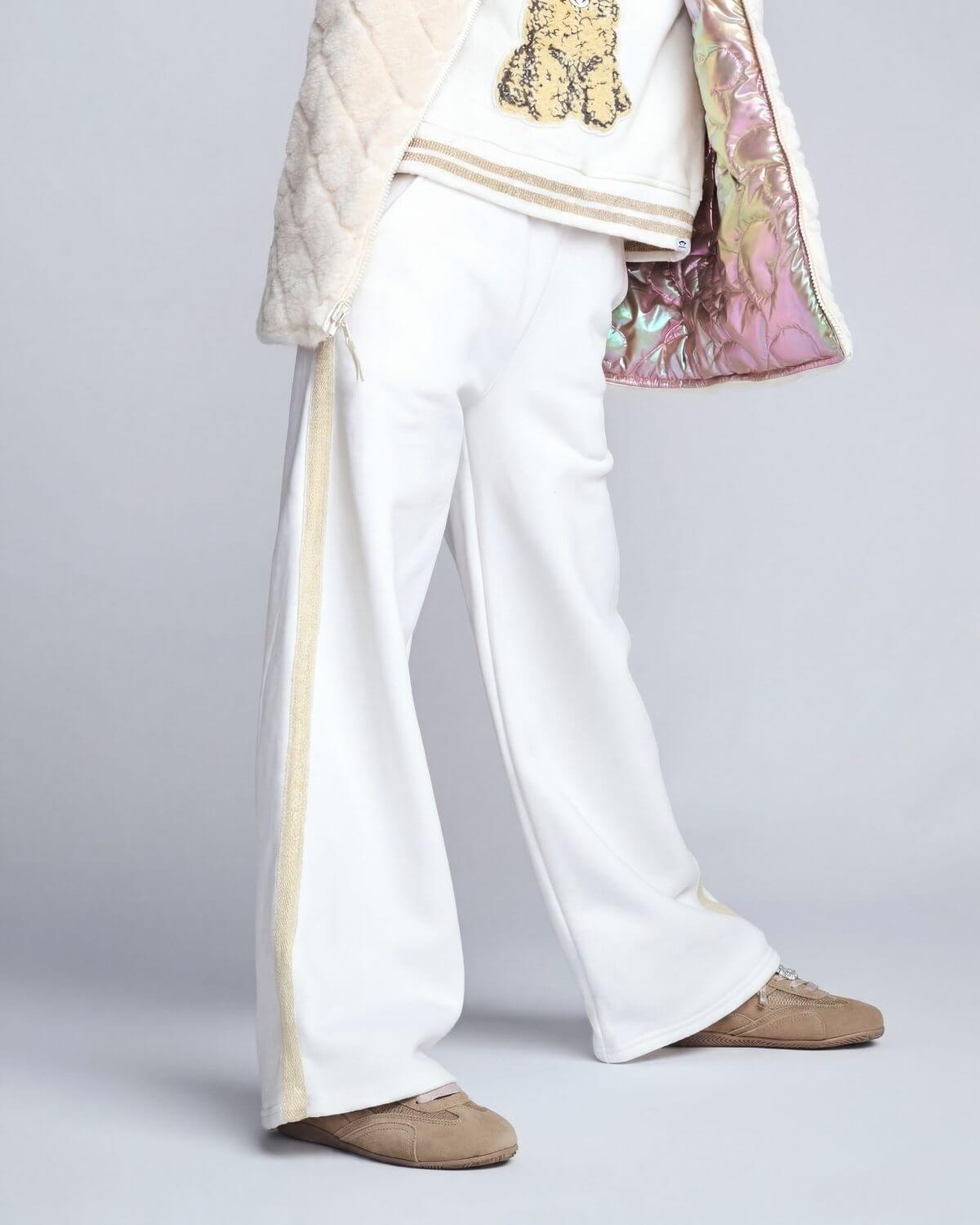 Traditional outfit with white pants, beige top, and multicolored jacket on a light gray background
