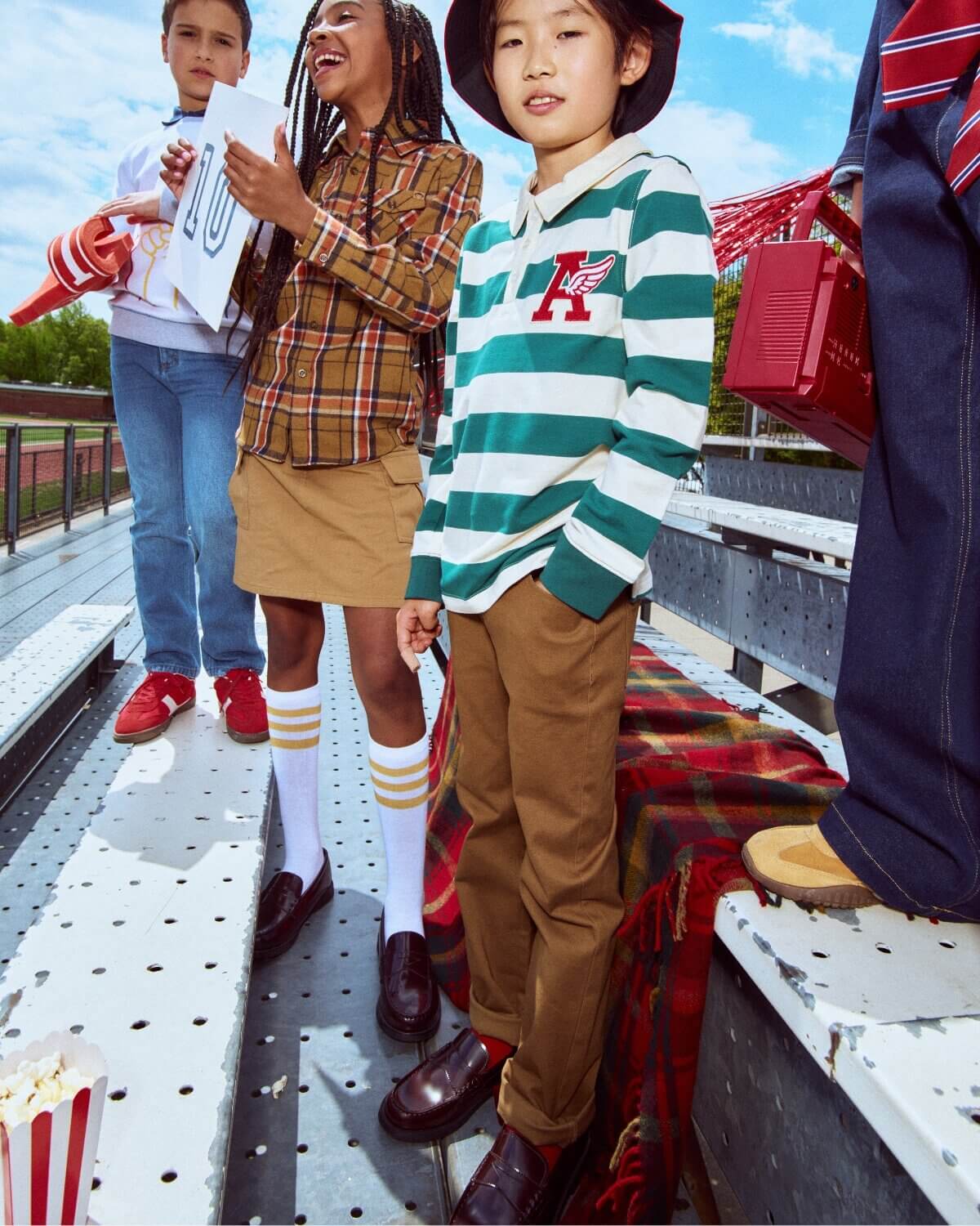 Children in stylish outfits standing on a platform with a colorful background