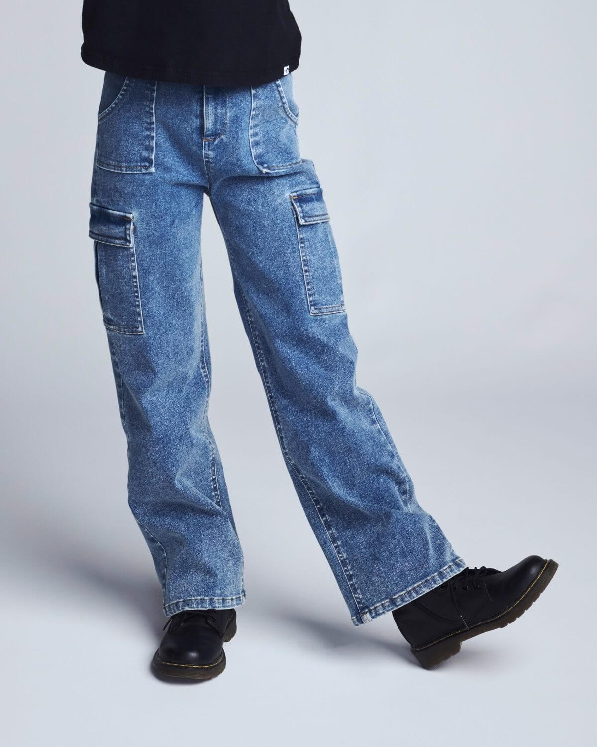 Blue jeans worn by a person on a light gray background