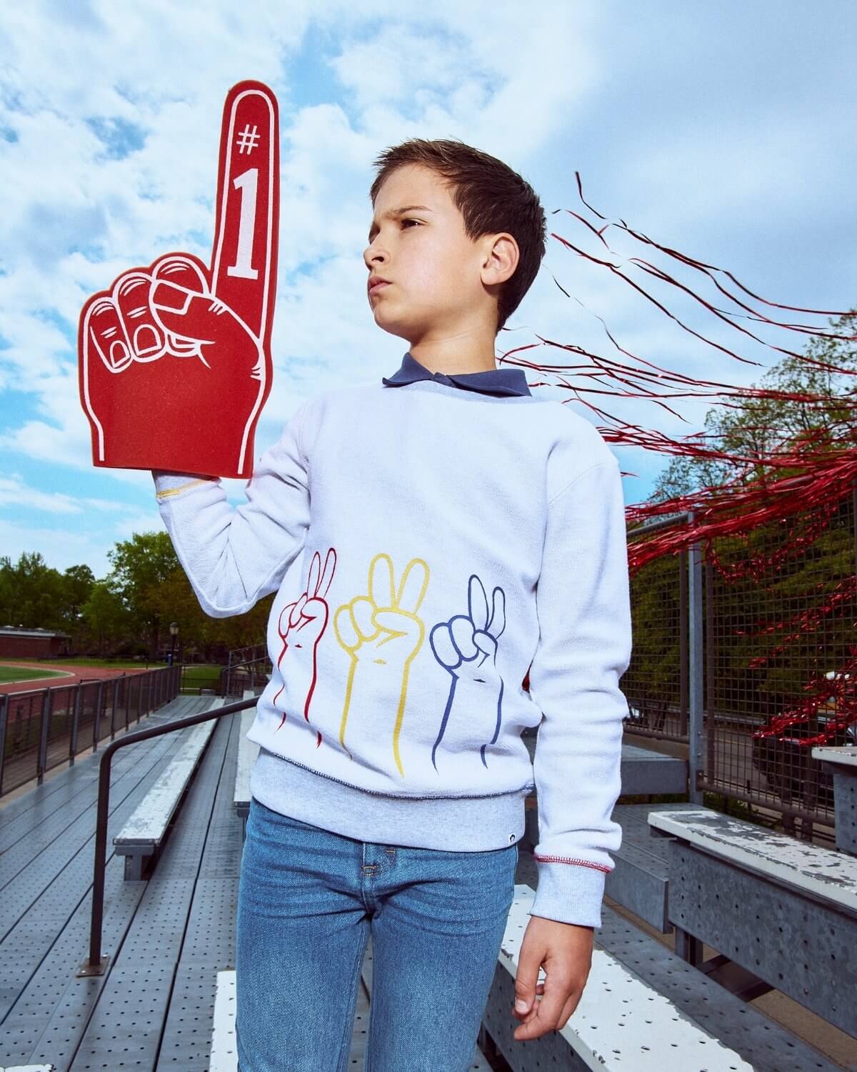 Child holding a foam finger with the number one outdoors