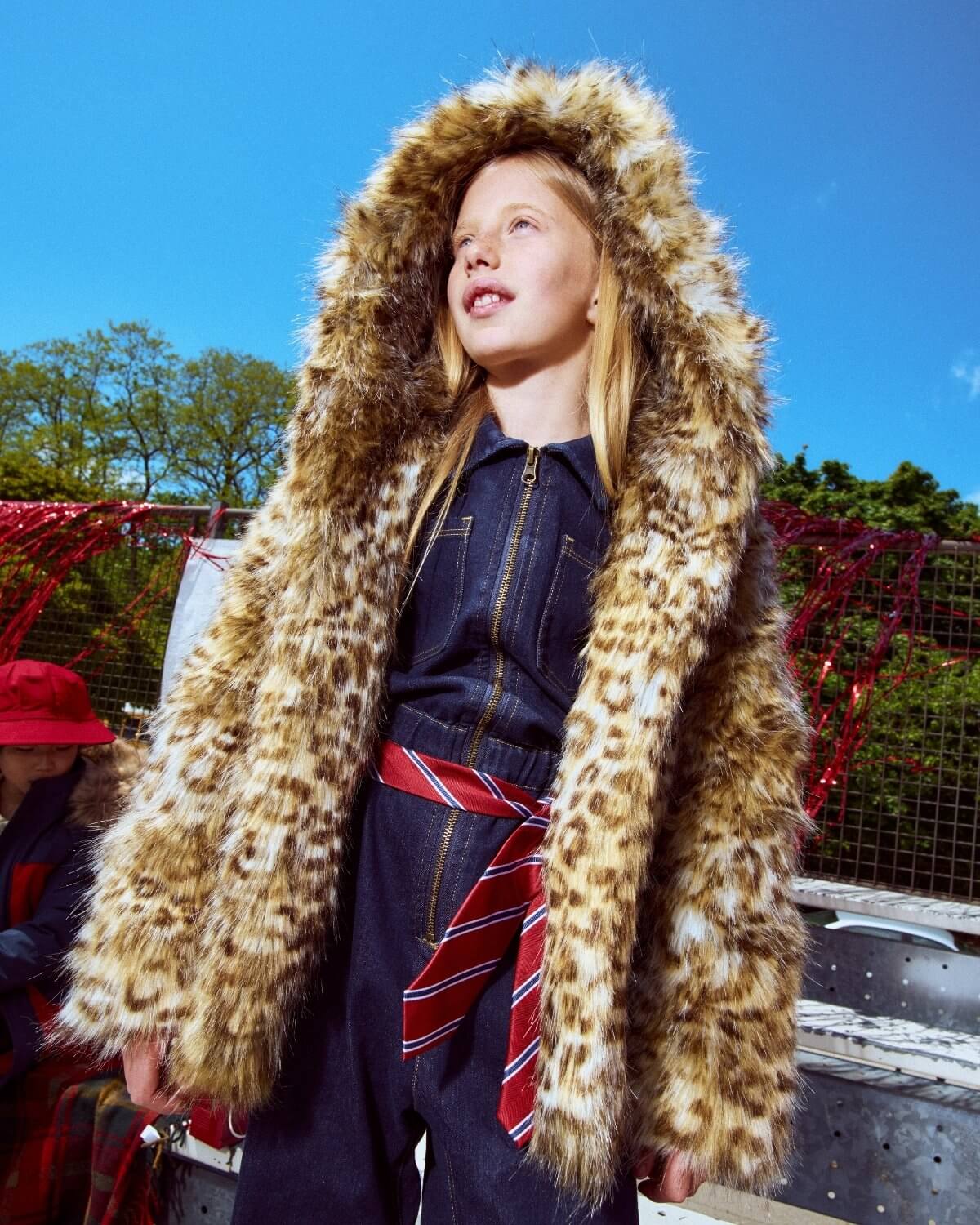 Person wearing a leopard print coat with a blue background