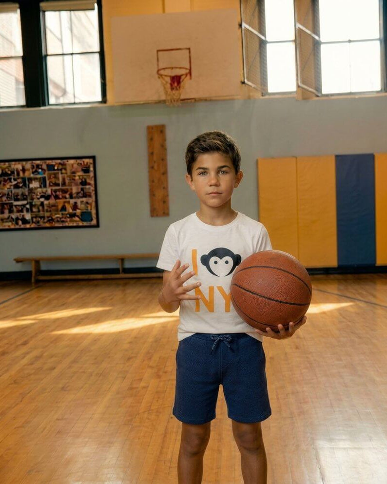 Child holding a basketball in a gymnasium