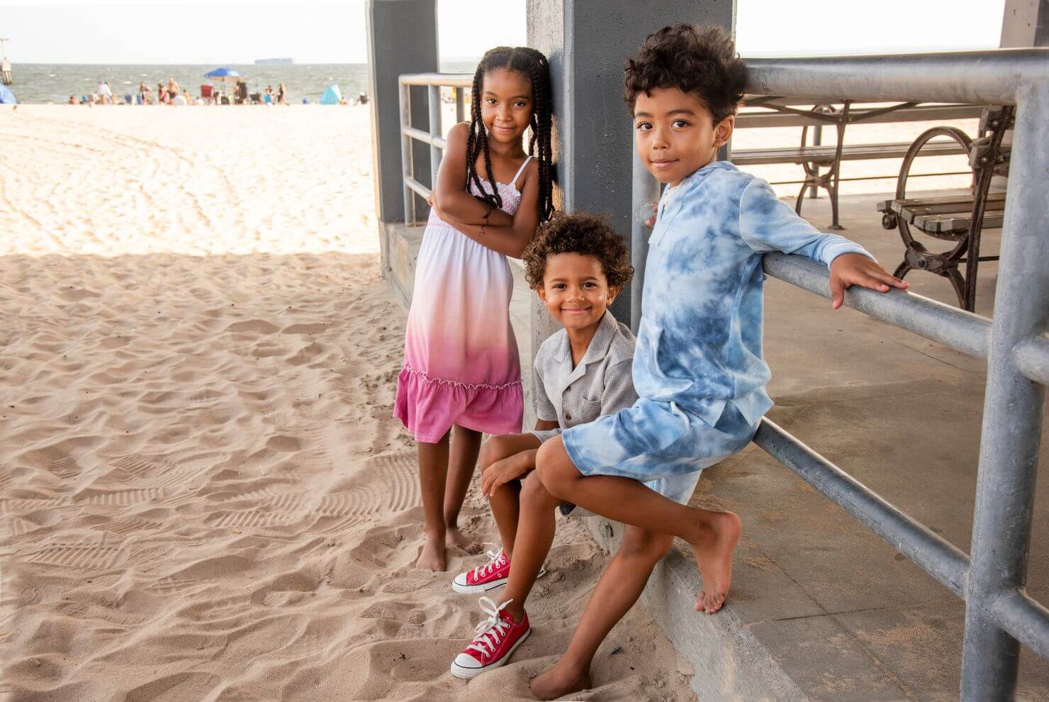 Three stylish kids at the beach in playful outfits, showcasing Appaman's trendy summer fashion for boys and girls.