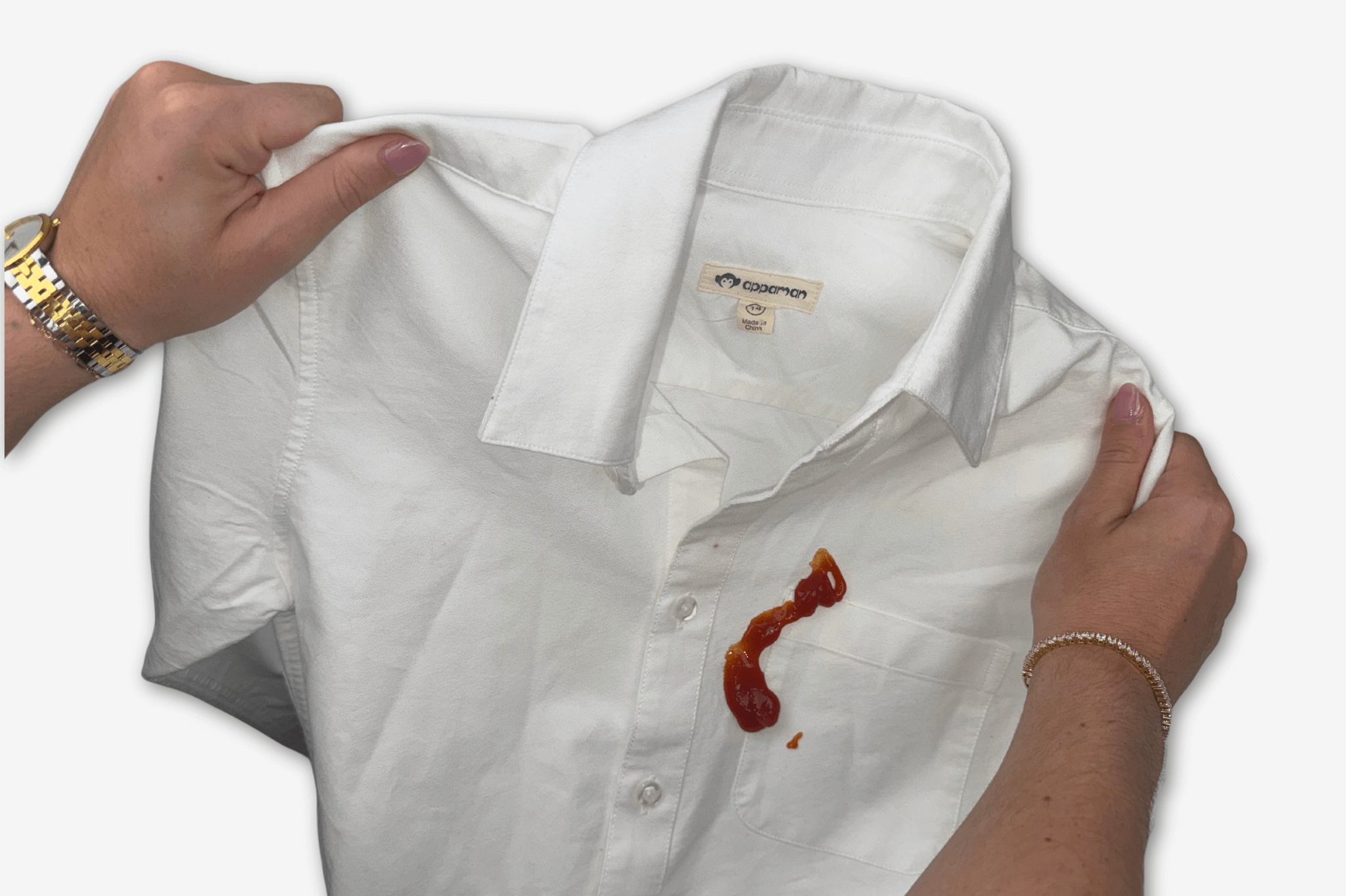 Hands holding a stained white shirt with ketchup, perfect for discussing tough stain removal tips for kids' clothes.