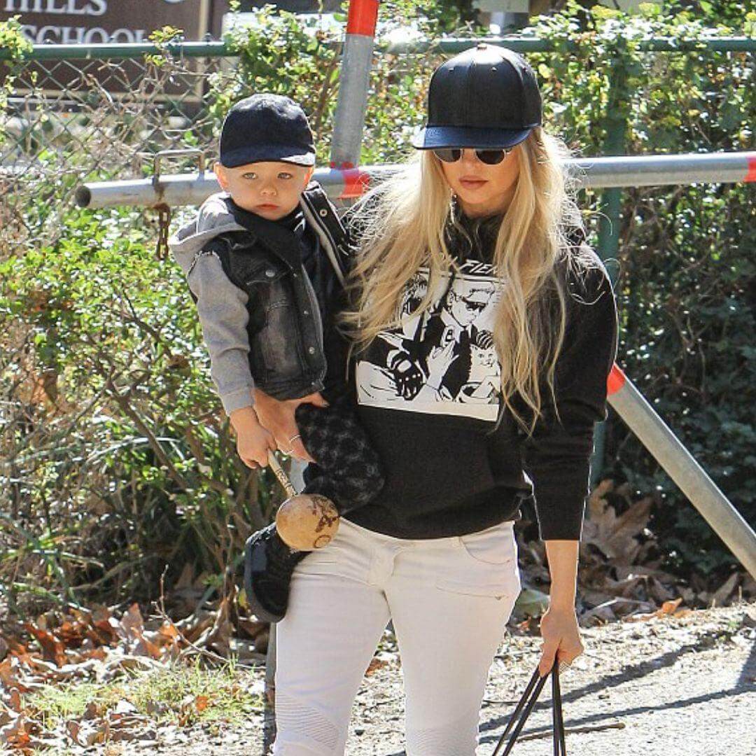 Fergie stylishly walks with Axl, sporting an Appaman jacket, showcasing playful parent tips for kids' styling.
