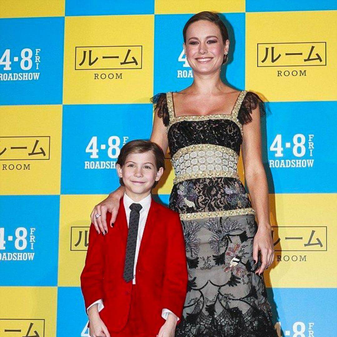 Jacob Tremblay in a sharp red suit poses with Brie Larson at the 'Room' Tokyo Premiere, showcasing stylish kids' fashion.