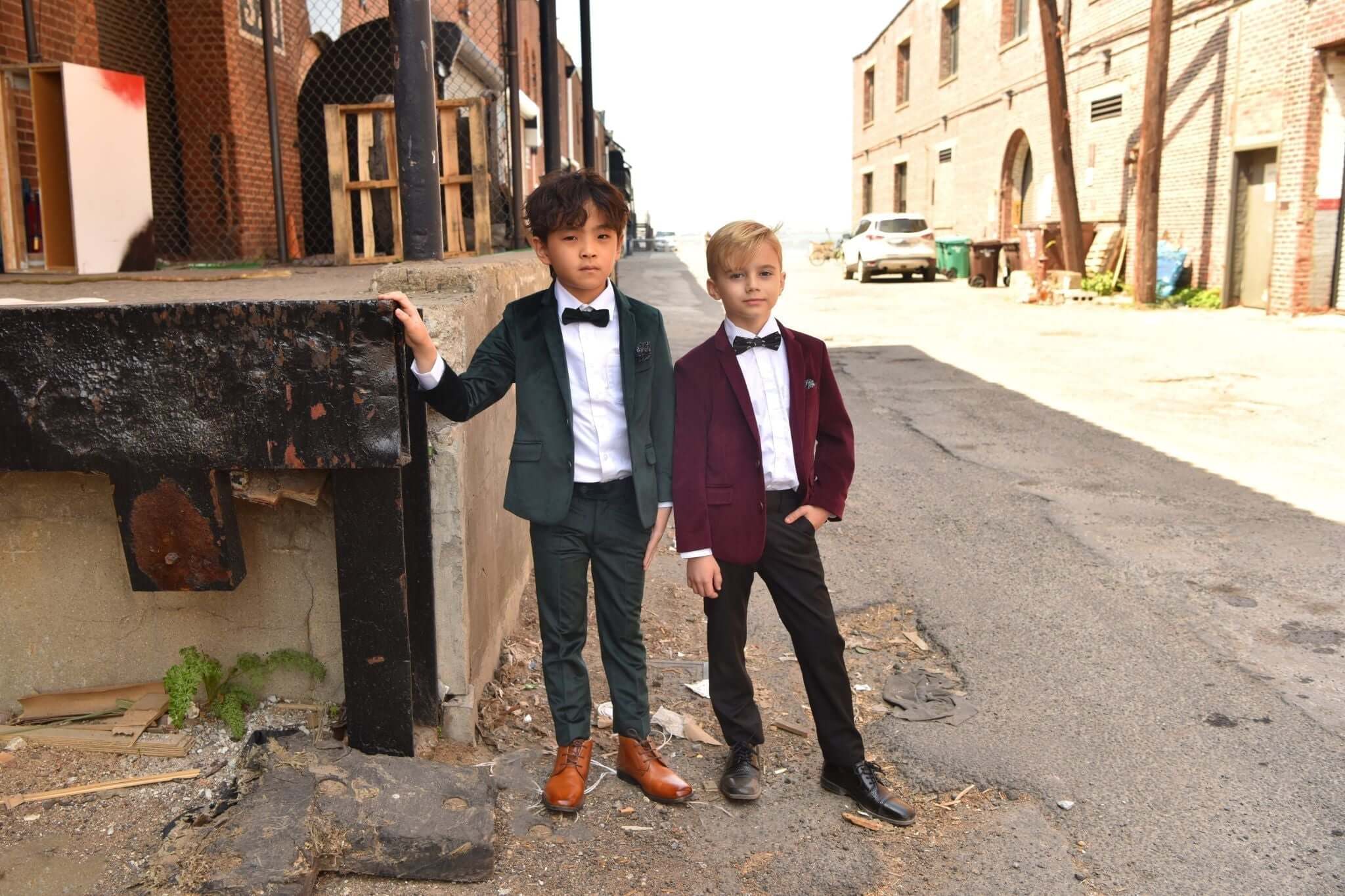 Two stylish boys in chic suits pose confidently in an urban setting, showcasing Appaman's trendy dance outfits.