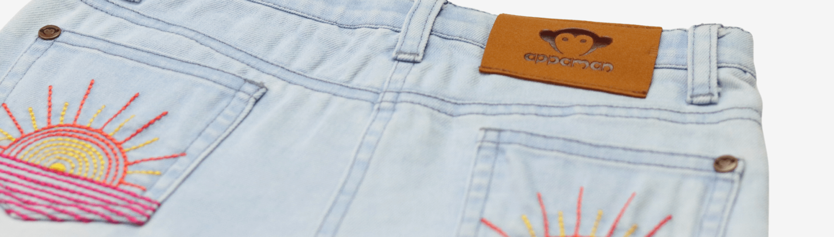 Stylish denim shorts with playful sun embroidery, perfect for trendy summer kids' outfits.
