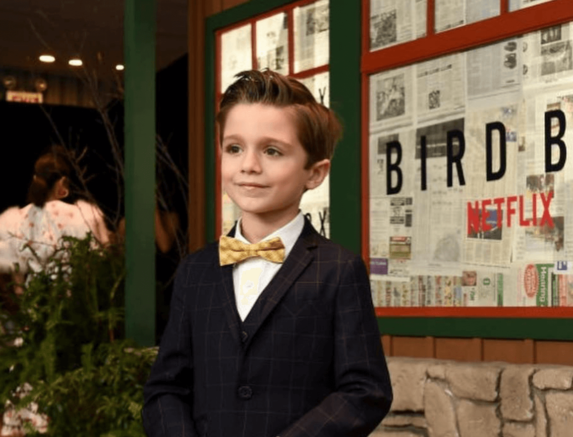 Julian Edwards flaunts stylish kids fashion at the Bird Box premiere, showcasing modern boys' suit and playful bowtie.