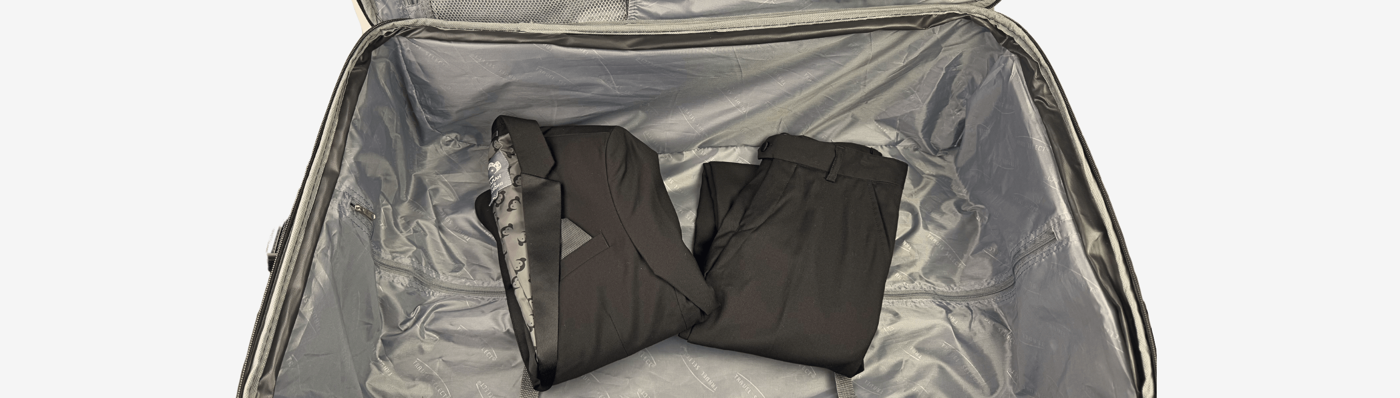 Neatly packed suit and trousers in a suitcase, showcasing stylish travel organization for kids' fashion.