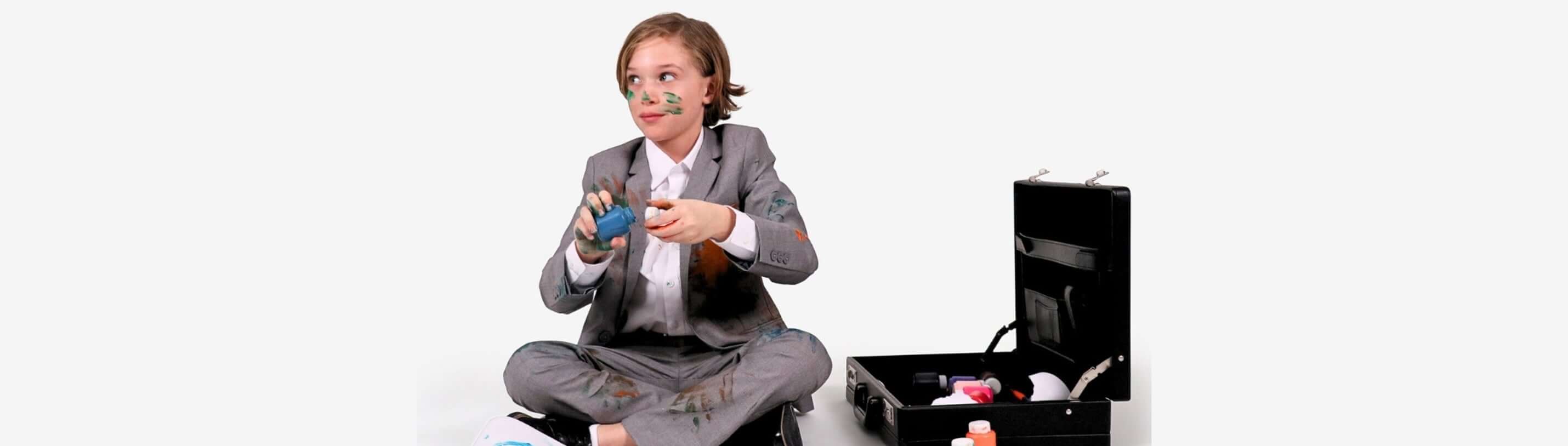 A stylish kid in a suit having fun while playing, showing that suits can be playful too!