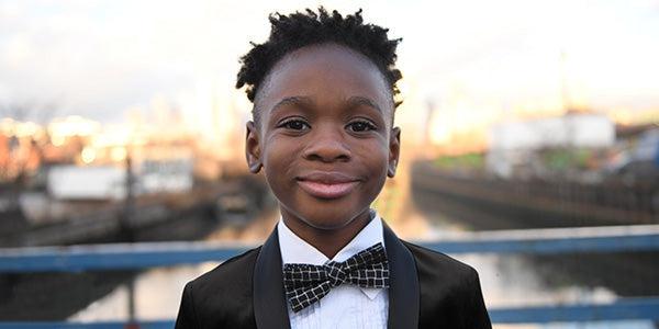 Stylishly dressed boy in a tuxedo with bowtie, ready for festive celebrations and special occasions.