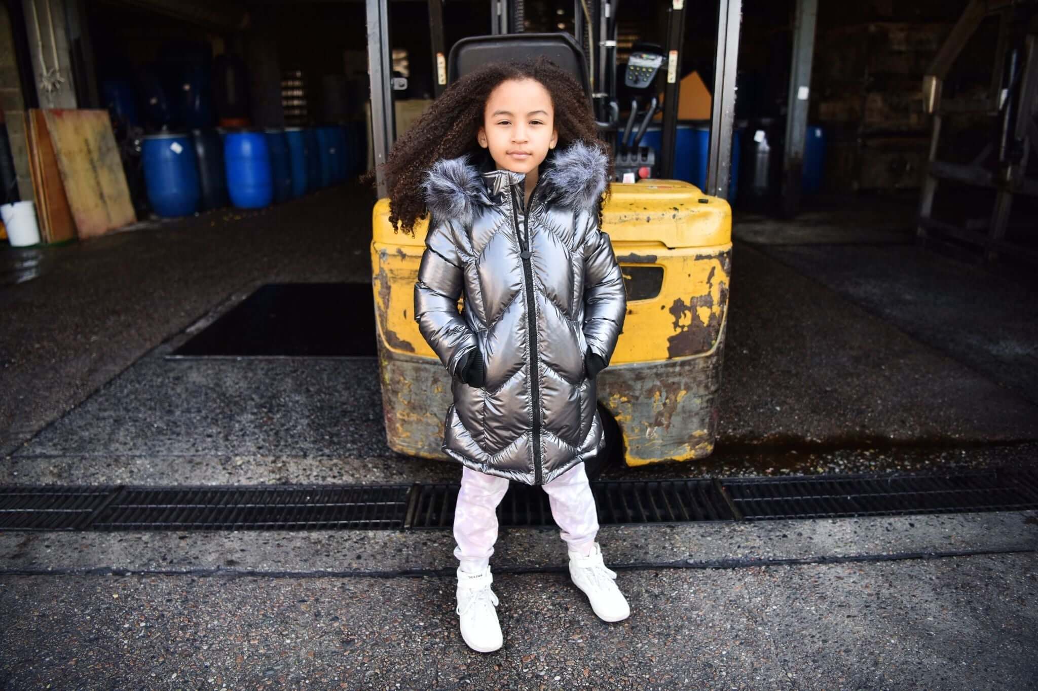 Stylish girl in a metallic down coat, exuding winter vibes while showcasing trendy kids' outerwear from Appaman.