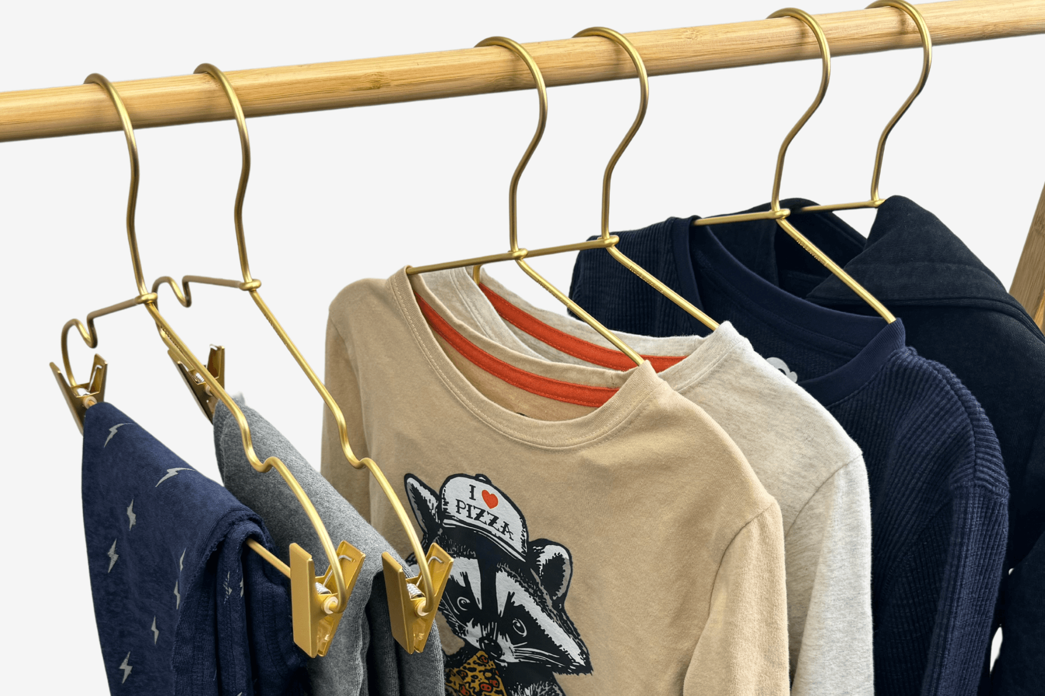 Stylish kids' shirts hanging on gold hooks, perfect for parent tips on kids' fashion and effortless styling.