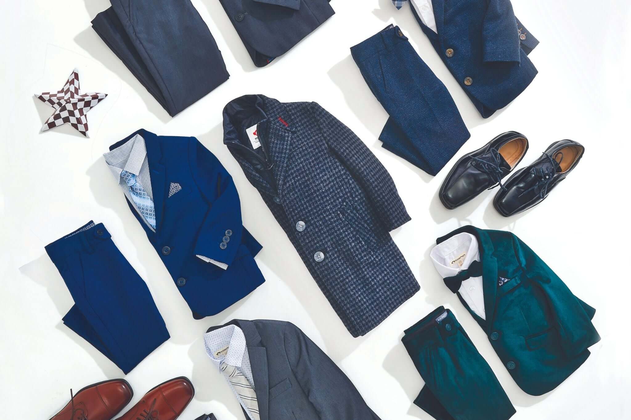 Stylish holiday outfits for boys featuring suits, coats, and shoes laid out for festive occasions.