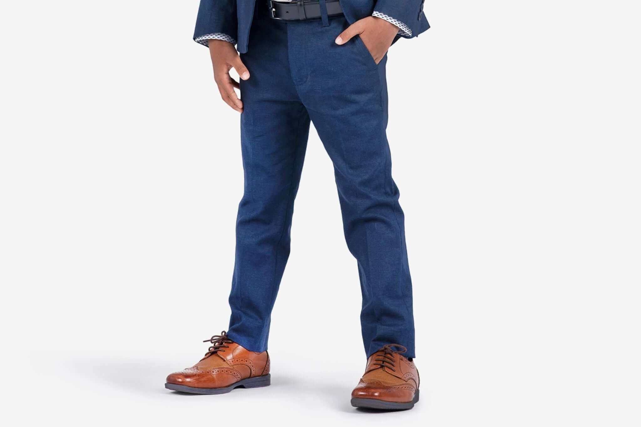 Stylish boy in navy pants paired with classic brown shoes, showcasing modern kids fashion and thoughtful styling tips.