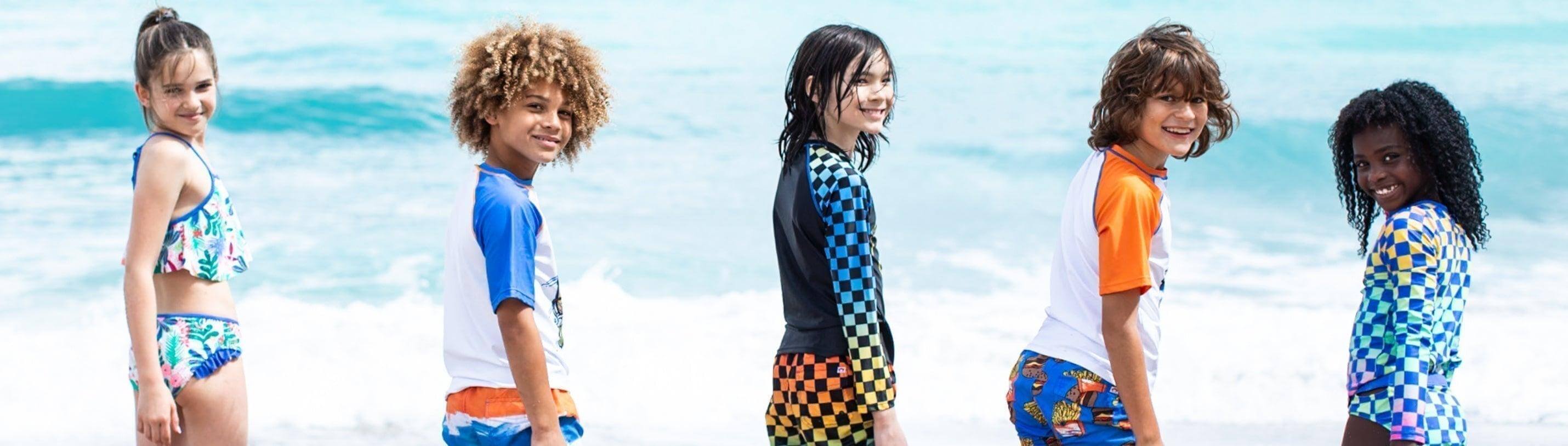 Trendy kids in colorful swimwear enjoying a sunny beach day, showcasing stylish sun protection options.