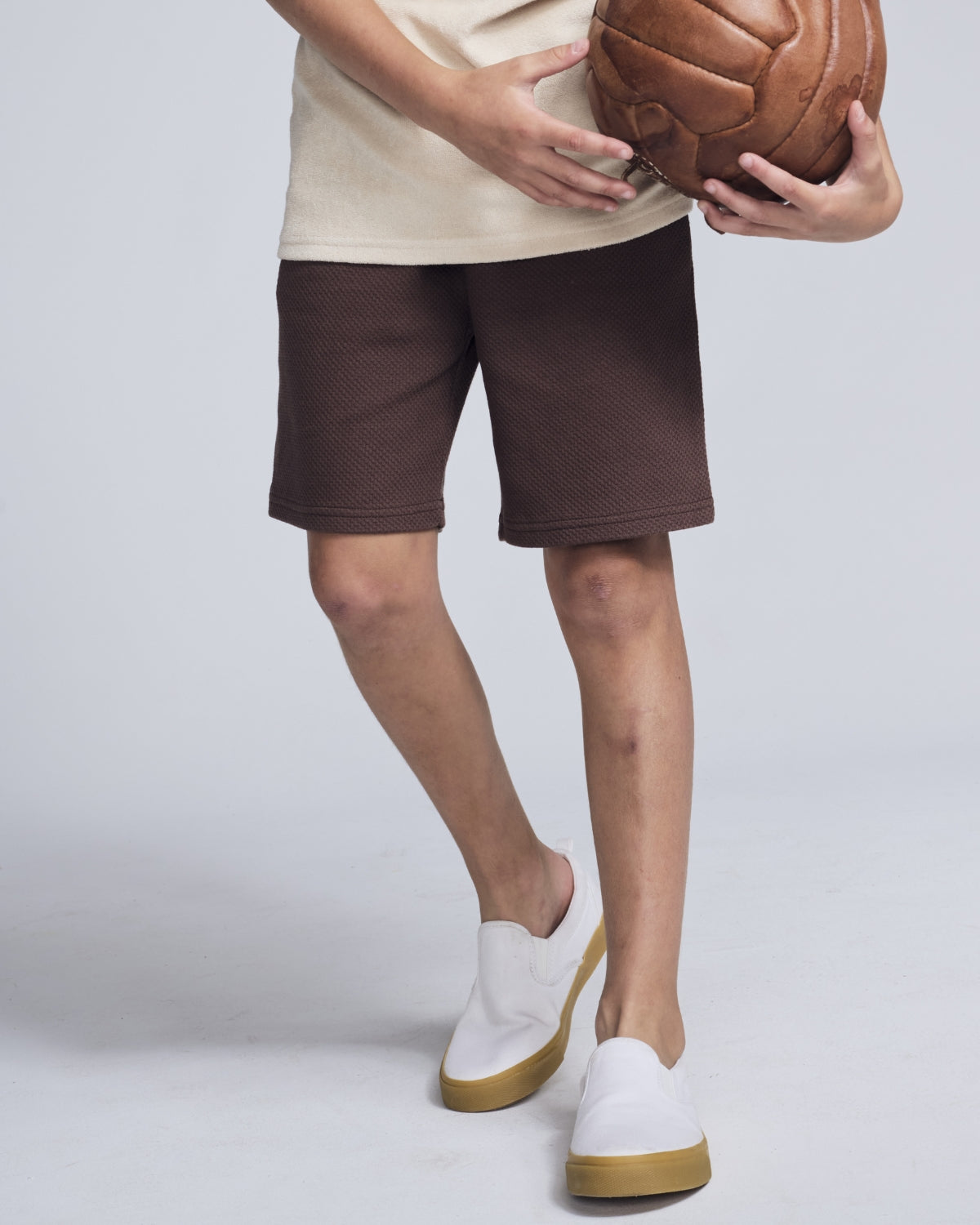 Boys' Shorts in brown worn by a child holding a basketball, perfect for summer activities.